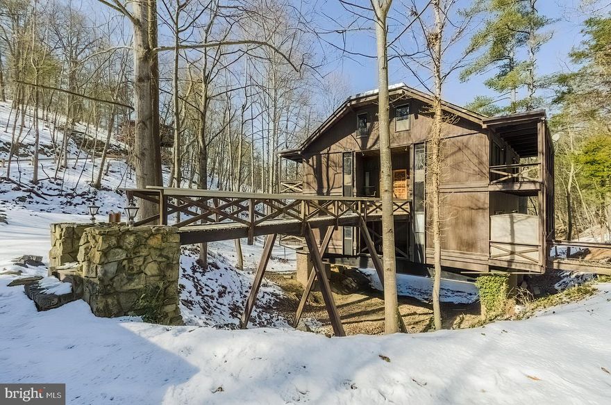 Your first thought is: "What, there's a 'House Over the Pond'"?  Yes, there is!! and 'HOP' is a unique mountain retreat that will have you excited about getting away.  Current owner has started the updating process, but is leaving the fun rooms to the new owner so you can make it perfect. All New: Luxury Vinyl Plank flooring on the main level and new carpet in the loft bedroom, 2 slider doors to back deck, upper picture windows, HVAC system, updated plumbing and freshly painted on the 2 upper levels.  The fireplace flue has been replaced making this sunken space THE focal point in the home.  Exposed beams and wood trim throughout the upper levels, cathedral ceilings in the Great Room and the floating fireplace bring rustic mountain charm to this home.  The kitchen and baths await your upgrades as well as the basement which has many possibilities!   You will be taken back to the 70's when you lay your eyes on the loft bathroom design.  Don't take my word for it, this is a must see!!