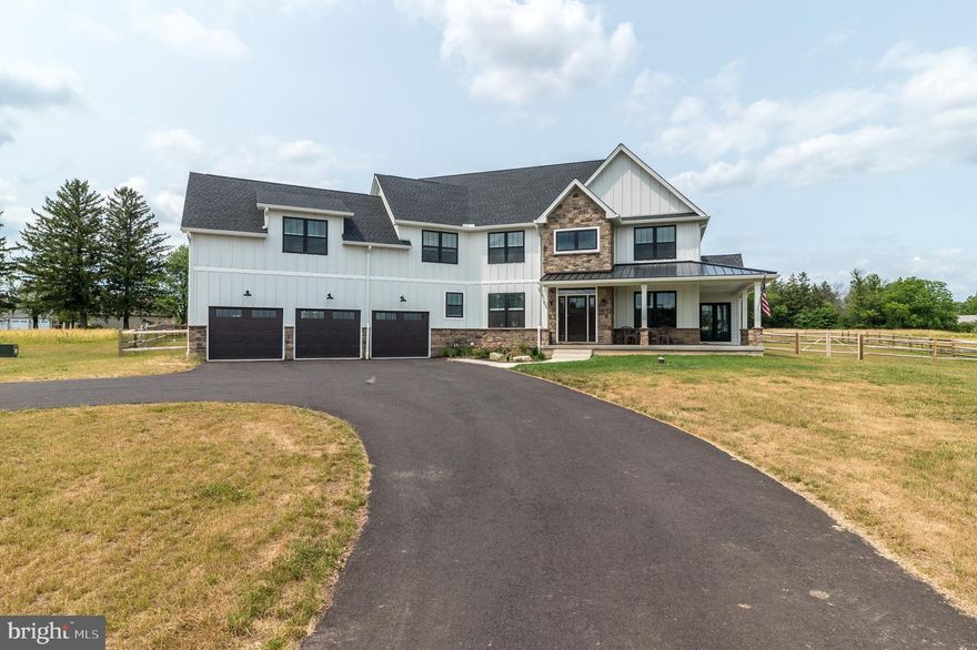 Welcome to Labrador Landing, a 1 year young, custom built modern farmhouse dream home by Lynn Builders. This sprawling 3,872 sqft beauty is located in the quiet rolling hills of the beautiful Bucks County countryside on one of the most majestic streets in Hilltown Township. Set on 6.82 scenic acres w/ long distance views from the wrap around front porch all the way to Center City Philadelphia, this exceptional home sits on a level piece of heaven, yet surrounded by trees for ultimate privacy. It's the perfect country setting to raise your horses, goats, & chickens, yet also only a short distance to downtown Doylestown, quaint Perkasie Boro, an easy drive to Allentown, & just mins to Rte 309 for easy access to the Septa Rail line to access Phila. The long winding driveway leads you to this impressive home flanked with maintenance free Hardie Plank & stone on the exterior. Travel down the heated sidewalk (for snowy days) up to the wrap around front porch with access to the main entrance as well as private office around the side. Inside, see all the fine features and attention to detail this home has to offer. A 2 story foyer welcomes you to the open floor plan with neutral paint & hardwood flooring throughout w/ the focus on the beautiful turned staircase w/ wrought iron balusters. To your left is the dining room with tray ceiling and gorgeous iron light fixture & side wall sconces. The space to the right is loaded with sunlight, perfect for your Grand piano or a reading nook & finished off with tray ceiling. Step through the double French door home office accented with pitched wood plank ceiling, loads of natural light, chandelier, & California Closets custom built-in bookcases. This office has its own access to the exterior making it the perfect spot to run your business. The heart of the home is the gorgeous chef’s kitchen featuring white cabinetry w/ slow closing doors, granite counters, tile backsplash, stainless steel appliances including a double wall oven and oversized cooktop w/ vented hood, & walk-in pantry. The giant center island has plenty of space for meal prep & gathering, also makes a great spot to sit & sip your morning coffee while gazing out the double doors to your private fenced in backyard. There is also a composite deck & exterior gas hookup for your grill or hot tub (hot tub not included). Just off the kitchen is the soaring two-story great room w/ exposed rustic wood beams, stacks of windows offering backyard views & natural light, & gas fireplace surrounded by locally sourced stone spanning the entire height of the wall. A mud room with sliced brick flooring is located just off the kitchen & offers access to coat closet, separate laundry room with built-in cabinetry & granite folding counter, & entry into the oversized 3 car garage with pre-wiring for 2 EV chargers. Perfect for a workshop, this garage is finished with many windows, side entry door, & has a gas hookup for a heater offering year round usability. Make your way back in, past the powder room and upstairs to the wide open hallway and balcony. Enter the double doors into the massive owner’s suite & be amazed. There is a huge separate dressing area/flex space w/ his & her closets and/or space for a workout area. The main bathroom features a large freestanding tub, luxury tile flooring with radiant heat, double sinks with granite vanity, a huge walk in shower, linen closet, & private toilet closet. Three additional spacious bedrooms down the hall all feature ceiling fans & large closets, & share the well appointed hall bathroom boasting trendy floor tile with radiant heat & double sinks with quartz vanity. The basement has unlimited potential with its high ceilings & 1,794 sqft of space. This home has 2 zones of heating & cooling,  pre-wired for solar panels as it faces South, 600 AMP electric service, upgraded sprinkler system, warranty on septic system, contin. recirculating H2O system w/ softener & filter, & so much more!