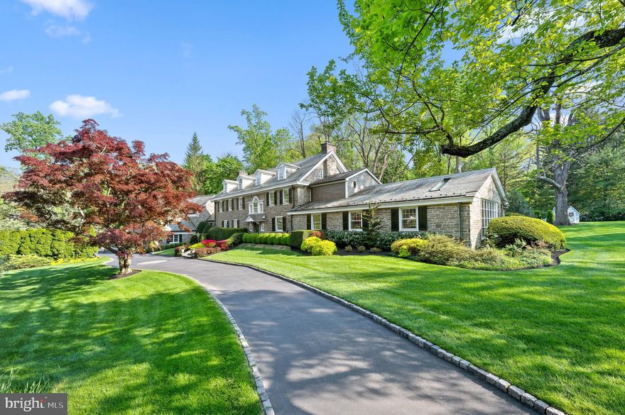 Welcome to 221 South Aberdeen Avenue, a hidden gem quietly nestled on two breathtaking acres in the heart of South Wayne, where the TAXES HAVE BEEN REDUCED and are reasonable for an estate property of this grandeur!!This grand stone estate, constructed on all four sides, has remained one of Radnor Township’s best-kept secrets for nearly a century. Surrounded by lush, mature landscaping and offering unmatched privacy, it’s a rare opportunity to own a true legacy property within walking distance to downtown Wayne. Step inside to an expansive front-to-back Foyer capturing views of the backyard oasis with stunning fountain setting the tone for this grand dame. Flanked by a formal Living Room with a floor-to-ceiling bay window and spectacular fireplace, and a Dining Room with deep windowsills, the home is filled with natural light and timeless charm. A cozy Breakfast Room with its own fireplace connects seamlessly to the updated Kitchen featuring high-end appliances, custom cabinetry, and granite countertops, maintaining an open feel ideal to create gourmet meals for entertaining and everyday living. From the Kitchen, enter the   glorious Sunroom with a hand-painted ceiling—an architectural jewel that connects the original home to the dramatic Great Room addition. With soaring ceilings, a custom hand-carved bar, and stained glass windows that fill the space with color and warmth, the Great Room is the ultimate entertainer’s dream. French doors open to a large deck that overlooks the expansive grounds, providing seamless indoor-outdoor flow. Off the Great Room is a private Office and Full Bathroom, making this area ideal for a guest suite, in-law accommodations, or a secluded work-from-home space. Whether hosting a garden party or enjoying a quiet morning coffee, the outdoor spaces offer unparalleled peace and privacy. Upstairs, the gracious Second-Floor landing features a beautiful arched window and window seat that add charm and character. The luxurious Primary Suite is a true retreat, offering His and Her Bathrooms and an incredible walk-in closet with exposed stone walls. Three additional Bedrooms and Two Full Baths provide ample space for family and guests. A well-positioned Laundry Room sits just off the back staircase, which offers direct access to the kitchen, making daily living effortless. The Third Floor features Two more Ensuite Bedrooms, perfect for extended family, guests, an au pair, or older children seeking their own space. These Upper-Level Rooms continue the home’s tradition of gracious scale, classic details, and exceptional versatility. Completing the home is an oversized 5-car garage—a rare and highly sought-after feature on the Main Line—paired with a convenient Mudroom area that keeps daily comings and goings beautifully organized. Behind the scenes, all major systems have been updated and are state-of-the-art, ensuring maximum comfort, efficiency, and peace of mind. The home has been meticulously maintained, a reflection of thoughtful ownership and timeless quality. The Lower Level offers yet another extraordinary feature: a custom walk-in, temperature-controlled Wine Cellar —perfect for collectors and entertainers alike. From its soaring ceilings and hand-carved woodwork to its tropical indoor pool and private outdoor entertaining spaces, 221 South Aberdeen Ave is truly one-of-a-kind. With its rare combination of architectural integrity, modern functionality, and walkability to everything Wayne has to offer, this home presents an opportunity that only comes along once in a generation!!