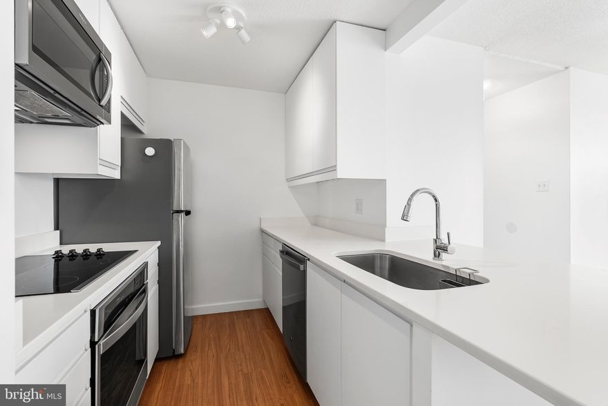 Experience elevated urban living in this beautifully renovated 1-bedroom, 1-bath condo in the heart of Mount Vernon. Perched on the 7th floor of a secure, doorman building, this stylish unit blends historic charm with modern upgrades. the unit has since undergone a complete transformation. The kitchen has been fully transformed and reimagined with sleek under cabinet lighting, an electric cooktop, built-in oven and microwave, dishwasher, and garbage disposal, creating a space that’s both functional and elegant.

Refinished hardwood floors run throughout the unit, enhancing the warm and inviting atmosphere. The bathroom has been completely remodeled with granite tile floors, a new sink and countertop, a backlit mirror, and a classic tub/shower combo. A custom brick accent wall adds a touch of industrial style to the space. The bedroom and living room are both outfitted with solar shades, offering privacy while still allowing soft, natural light to pour in.

Comfort is key with a brand new HVAC system installed in 2020—a Carrier 1.5-ton 14 SEER heat pump with a smart Nest thermostat—recently serviced in January 2025. The water heater shutoff valves were also replaced in April 2025, giving peace of mind to the next owner. A dedicated storage unit (#6) is conveniently located on the same floor, and parking is available for a monthly fee in the garage directly beneath the building.

The building itself offers 24-hour doorman service, an on-site convenience store, and a comprehensive HOA that currently includes water, trash, building insurance, and common area maintenance.  Situated in one of Baltimore’s most walkable and culturally rich neighborhoods, this condo places you just steps from restaurants, cafes, museums, and transit—making it an ideal home for city lovers, first-time buyers, or savvy investors alike