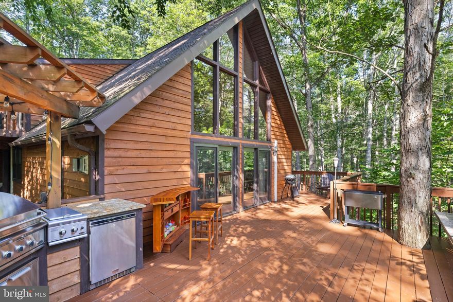 TURN-KEY MOUNTAIN CHALET WITH GUEST SUITE, RIVER ACCESS & GENERAC BACKUP-JUST 2 HOURS FROM NORTHERN VIRGINIA. Interior photos coming 8/6. Tucked inside the private, gated, and amenity-rich community of The Crossings at the Cacapon, this turn-key mountain escape is the perfect answer to busy Northern Virginia life—just a 2-hour scenic drive from the Beltway. With space to host everyone and the infrastructure to live here full-time, this property is equal parts retreat and residence.
Designed with flexibility and comfort in mind, every level of the home offers its own bedroom and living space, making it ideal for multi-generational living or hosting a crowd. Inside, you’ll find vaulted ceilings, hardwood floors, granite countertops, a double oven, and tiled bathrooms, blending the warmth of a chalet-style cabin with thoughtful modern upgrades. A private apartment above the oversized 2-car detached garage features its own kitchen, full bath, and open-concept layout—perfect for guests, in-laws, or adult children & hosting the grandkids. A deck connects this suite & the lofted primary suite in the main house, with a staircase from the parking, offering privacy and accessibility. A separate single-bay garage adds even more storage or workshop potential & toy storage. Outdoor living takes center stage with a screened-in porch, custom granite fire pit, and a fully outfitted outdoor kitchen—tailor-made for stargazing, grilling, and long evenings with friends and family.  Please see documents for items to convey & more.
This property is packed with upgrades and built-in peace of mind:
Whole-house Generac generator
3 propane fireplaces
Brand-new on-demand water heater
New well pressure tank
Whole-house water filtration system
New washer and extra freezer
50-year architectural roof (installed 10 years ago) with flip-down gutters for easy maintenance
Frontier DSL internet for reliable remote work and streaming.
Even better—it’s completely turn-key. THE FURNITURE CONVEYS, (staging items do not convey) along with 3 kayaks, life preservers, and a Polaris UTV, so you can immediately enjoy everything this lifestyle has to offer. The Crossings is a low-dues HOA community with well-maintained roads, offering multiple river access points, a walk-in boat launch, and direct access to the Cacapon River—one of the cleanest in West Virginia—ideal for kayaking, swimming, or fishing. You'll also enjoy a community pavilion, walking trails, basketball courts, swings, and regular neighborhood events. While Short-term rentals are not allowed, this preserves the peace, privacy, and community feel of this approximate 125-home enclave. Whether you're looking to summer in the mountains or make it your full-time escape, 211 Crossings View Road is a rare find—fully equipped, thoughtfully upgraded, and ready for you.