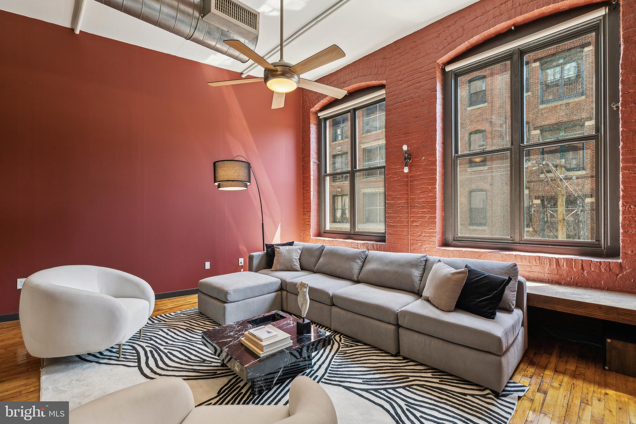 Welcome to 428 N 13th Street, Unit 3G — a meticulously renovated residence in the iconic Hat Factory Lofts, where historic charm meets modern elegance. This sophisticated 1-bedroom loft with a versatile den/office overlooks the vibrant Rail Park and offers a perfect blend of industrial character and elevated design in one of the city’s most dynamic neighborhoods.
Upon entry, you’re welcomed by a custom coat closet and beautifully restored original hardwood floors that flow throughout the home. Soaring ceilings and a gracious foyer create an airy, gallery-like ambiance. The private, spacious bedroom offers an oversized floor-to-ceiling custom closet system with beautiful custom doors while the adjacent den includes a rich cherry wood desk and bespoke cabinetry—ideal for a home office or flex space.
The luxurious bathroom boasts marble flooring, a whirlpool soaking tub, refined fixtures, and ample storage. The open-concept living and dining area is flooded with natural light from oversized windows, complemented by a marble window seat and painted exposed brick. The chef’s kitchen impresses with an oversized granite island, cherry cabinetry, and premium appliances, seamlessly blending form and function.
Exposed beams, elevated track lighting, and a sleek steel ladder leading to a charming loft area add to the home’s warm, industrial aesthetic. All this in a historically and visually unique part of Philadelphia and just steps from dining, culture, the Reading Terminal Market, museums, grocery stores, public transportation and so much more. Commuting within or out of the city from this property is quick and effortless.
The on-site garage offers the option for reasonably priced parking as well as a bike rack. Additionally, this well-appointed unit with low HOA fees is situated perfectly away from the street and within the hallway for added peace and quiet. Don’t miss this opportunity to make this wonderful property your next home.