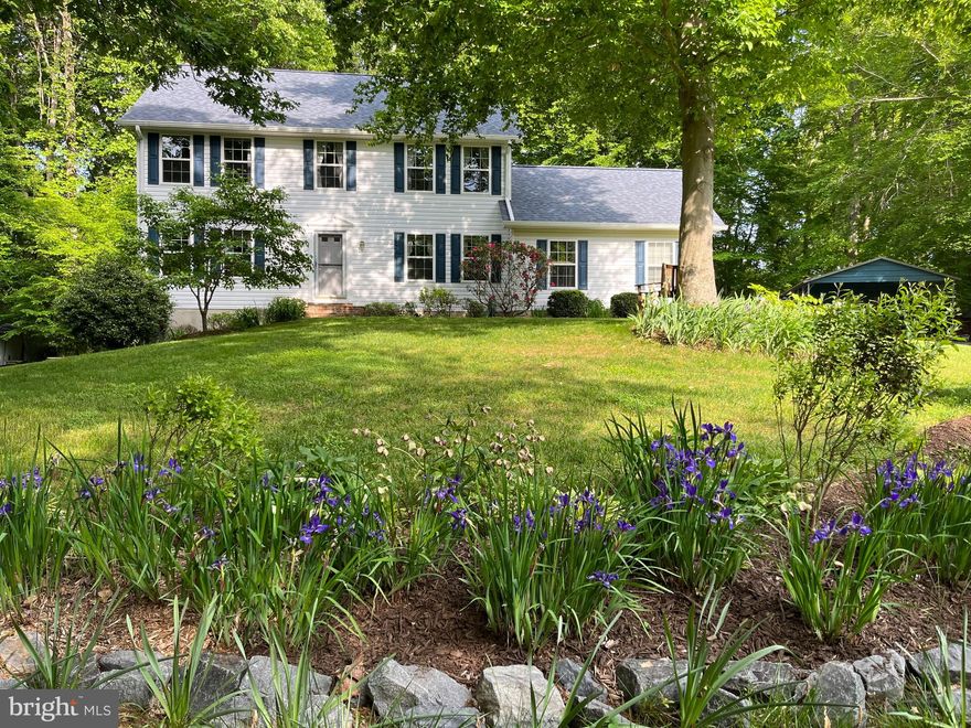 Price Reduction...   Great Opportunity...This Classic colonial has a private setting on 1.27 acres.  Plum Point Woods is a sought after community in the Huntingtown School District.  AND... No HOA!  This charming home with 4 bedrooms, 2.5 baths has formal Living & Dining spaces.  The Family room has a wood stove and the kitchen has bright white cabinets. Beautiful hardwood floors throughout the home except for kitchen & baths. There is a 2 car garage with a mudroom coming into the house to leave those coats and shoes.
The basement is partially finished.  Divided into rooms,... great space for a workshop, storage... whatever you might need.  
The exit to the back yard is level and an  easy access on the side of the house. 
The yard  has a small vegetable/ herb garden, beautiful perennial plants that you can enjoy year after year and berries galore!  Thornless blackberries, gooseberries, black raspberries, strawberries and a few red raspberries and a delicious peach tree and cherry tree.
This property is next to a conservation area... no neighbors building there...    Wonderful woods to explore!!!