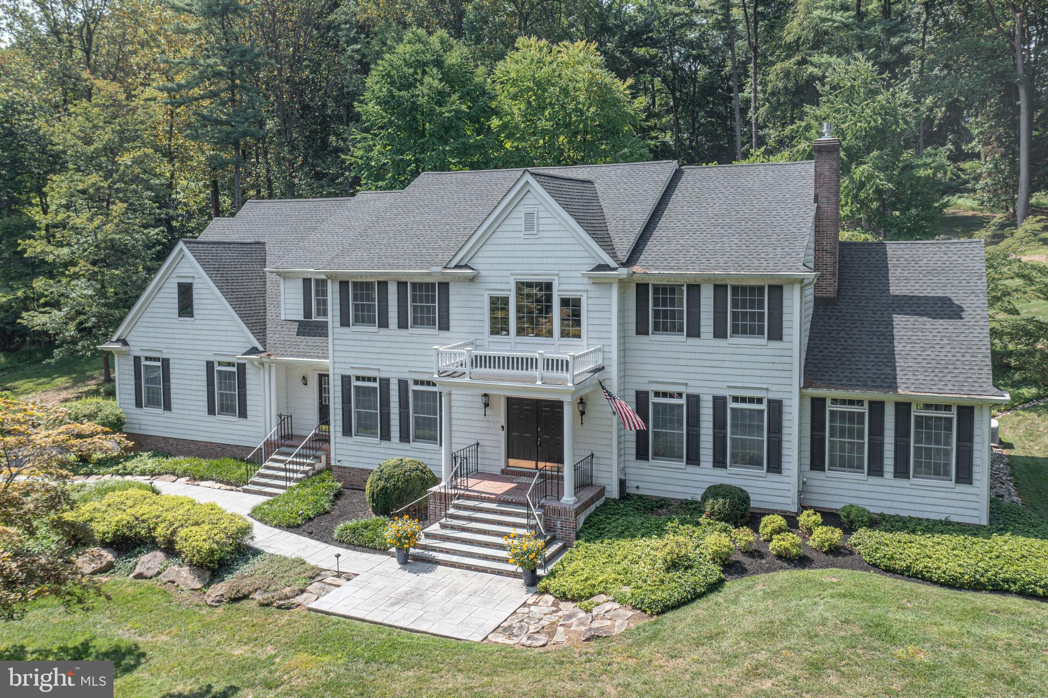 Nestled on nearly 2.5 acres within the prestigious enclave of Bellinghamshire Estates, this impeccably designed 4 bedroom and 4.5 bath residence epitomizes refined living, harmonizing architectural sophistication with modern comfort. Step inside to discover a gracious, two-story foyer, with plenty of sun-drenched rooms on the first floor and maple wood flooring mostly throughout. A formal dining room adorned with wainscoting flanks the home’s entryway on one side while a stately living room with a gas fireplace and marble mantle flank the other side. Distinctive living spaces also includes a Conservatory with walls of windows showcasing the beautiful, natural backdrop and a paneled library with custom bookshelves. The nearby gourmet kitchen is outfitted with high-end appliances, handcrafted cabinetry and a large island with counter seating, an expansive dining space and a fully outfitted butler’s pantry. Nearby is a soaring two-story family room anchored by a dramatic stone gas fireplace perfect for family gatherings. The upper level is dedicated to an opulent primary suite featuring a private sitting area, spa-inspired bath, multiple walk-in closets and a laundry room. Two large hall baths are shared by three additional spacious bedrooms. The Finished Lower Level allows for even more living space to and includes a home theater with surround sound and a full bath. Equally compelling is the outdoor environment, designed for both relaxation and grand-scale entertaining. The estate is set amidst meticulously landscaped grounds, offering both seclusion and grandeur. A Timbertek deck and stone patio, accent lighting, an integrated sound system, and mature specimen plantings create an idyllic al fresco retreat. An oversized, heated three-car garage further enhances the property’s convenience and functionality. This distinguished residence is perfectly positioned between New York City and Philadelphia. Nearby, Peddler’s Village provides premier shopping and dining, while the historic towns of New Hope, Lambertville, and Doylestown are just a short drive away. Set within the acclaimed New Hope-Solebury School District, this home combines convenience, culture, and prestige in an unparalleled location.