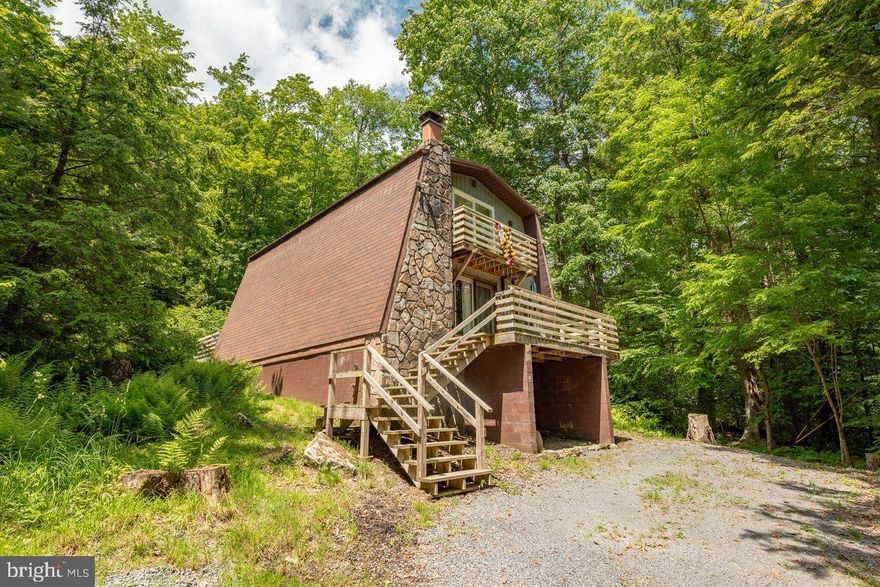 Cozy up at this charming modernized cottage tucked along the wooded hillside. With an open layout, stone fireplace, and plush furnishings, this is the place to return to after a busy day around the area. Enjoy your morning coffee on the Juliet balcony or the  front or back deck, or curl up in front of the newly updated wood fireplace in the living room. Enjoy some swimming, fishing, or kayaking at the community lake access point less than a quarter mile away or head out to see what all the area has to offer. As the sun starts to set, gather in front of the glow and warmth of the campfire around the fire pit before drifting off to sleep in one of the 3 cozy bedrooms. Nestled in the trees you’ll be immersed in the winter wonderland that is the snowy Deep Creek mountains! When you are finished with your adventures, allow the hot tub to soothe any aches and pains acquired throughout the day. Located just minutes from multiple State Parks, fantastic restaurants, and the four season Wisp Resort, you’ll never run out of things to keep you entertained.

Rentals on the books through August to date that transfer.

NEW: 2022 roof, 2023 hot tub, 2023 hot water heater, 2025 vinyl siding, 2026 front deck supports, 2023 fireplace insert & lining.