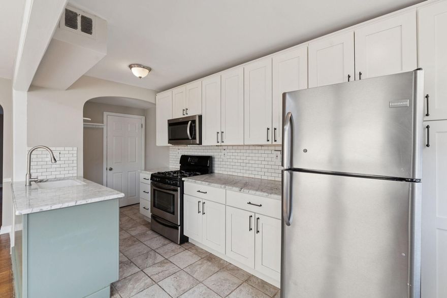 Welcome to this fresh, updated rowhome on a peaceful block in Mount Airy! This 3-bedroom gem balances modern finishes and open floor plan with the classic warmth of hardwood floors, built-in shelves, chair rail molding, and graceful arched entryways. A generous front yard and handsome brick facade greet you at the door, where a concrete patio extends your outdoor living space.
Inside, a large, sun-filled living room opens through an arched entryway into the dining room, which connects seamlessly to a thoughtfully redesigned kitchen. The kitchen features two-tone cabinetry, subway tile backsplash, a kitchen island with a double-basin farmhouse sink and marble counters, and stainless steel appliances.
Hardwood floors continue upstairs to three bedrooms where ceiling fans and abundant natural light await. A linen closet and a fully renovated bathroom featuring a glass slider, contemporary white tile, and marble-look floors complete the upper floor.
The finished walk-out basement adds versatile flex space, laundry area, and direct access to a private driveway and 1-car garage.
The location delivers on every front: Cheltenham and Cedarbrook shopping centers, Chestnut Hill's boutique shops and restaurants, and the trails and green escapes of Wissahickon Valley Park are all close at hand. SEPTA Regional Rail and multiple bus lines make commuting effortless.