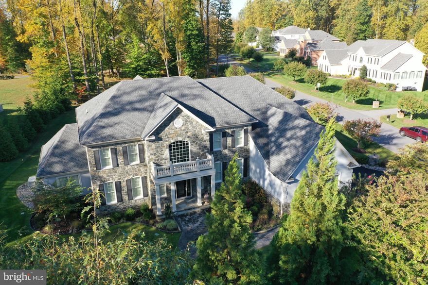 This immaculate residence is unequalled in design and has extraordinary upgrades, perfect for inside and outside living and entertaining.  Welcome guests with a paver walk, accent border, professional landscaping, and a rectangular portico covering an eight-foot leaded glass entry door.  Inside, arrival is celebrated with a grand two story foyer, two sweeping curved staircases, and two Juliette balconies embellished with iron balusters.  This quintessential Hampton model, designed and built by Toll Brothers offers a formal living room, conservatory and formal dining room flanking the primary foyer, while an extended foyer punctuated with four columns unfolds to the formal study, and a two-story great room. Outstanding features and upgrades include a coffered ceiling, soaring stone fireplace, plantation shutters, ornamental wall trim accents and a secondary back stair.   The hallmark chefs kitchen is at the heart of the home and has adjacencies from the great room, dining room, butlers service pantry, breakfast room, morning room and outdoor dining patio.  Gourmet kitchen upgrades include 42? cabinetry, exaggerated ogee-edged granite counters, decorative backsplash, and professional Jenn-Air appliances.  A commanding center entertainers island is host to a wrap-around bar bump-up, three pendant lights, and prep sink for the chef to cook, serve and entertain all at once!   Upstairs, the gracious open landing is embellished with iron balusters overlooking the foyer and the great room.  Hardwood floors are a striking unifying element, and travel throughout the entire upper level and stair cases.  Four bedroom suites each have a private attached full bath, and two bedroom suites include Juliette balconies. Luxury living is fully expressed in the Owners suite beginning with French doors opening into a spacious den and sitting room, followed by paired columns that transition to the suite bedroom.   Deep tray ceilings accent the bedroom area while a pair of French doors open to a sumptuous spa-like bath featuring separate vanities, soaking tub, decorative accent tile, and walk-in shower.  Completing the Owners suite is a walk-in dressing closet, and a second, hallmark bonus closet boasting more than enough space for the most extensive wardrobe.  Enjoy the comfort and beauty of outdoor living and entertaining at its finest with creative hardscaping integrating professionally designed landscaping and outdoor lighting.  A dining patio courtyard and built-in fire pit offer access to the breakfast room, kitchen and morning room and are perfect for impromptu meals and gatherings.  Extensive paver design unfolds to the soothing sounds of a gentle waterfall, rock garden, and cascading stone flower beds that mark entry to the circular stone terrace with lighted stair risers and an iconic stone feature fireplace.  This design and focal point stand at the ready to offer perfected outdoor living and gathering on a grand scale.  Additional upgrades and amenities outside include an epoxy finish, utility sink, plantation shutters and service door in the garage, generator, double door and wide walk-up stair from the lower level, a 24-zone irrigation system, dry stream rocks and swales and giant privacy evergreens.  Come home to uncompromising quality, comfort and ?better than new? luxury amenities at every turn. Simply immaculate!