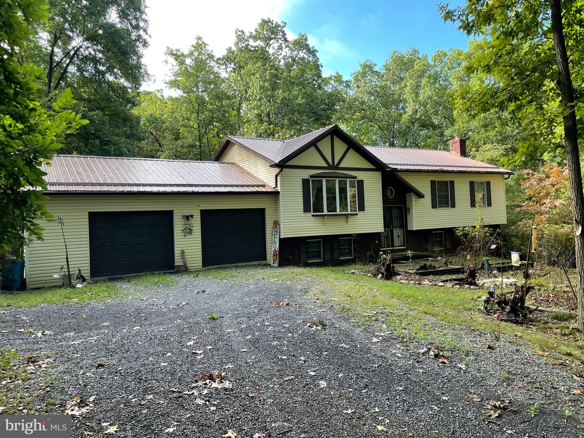 Well Kept, Move-in Ready home on 5 acres! Creek/Stream on Property! 3 bedroom 2.5 baths split-level home with attached 2 bay garage. This home boasts an open floor plan, double door entry, cathedral ceilings, red oak cabinets, pantry, gorgeous sun room with skylights, office space with pine wainscoting, laundry room, MacClean well water filtration treatment system, sliding glass doors, metal roof, 11X16 3 sided open wood shed, and a 10X7 closed shed. All of this on a secluded 5 acre lot in the woods in a safe subdivision with access to a private lake. Enjoy the privacy but still be within a short drive to town, Walmart, restaurants and more!