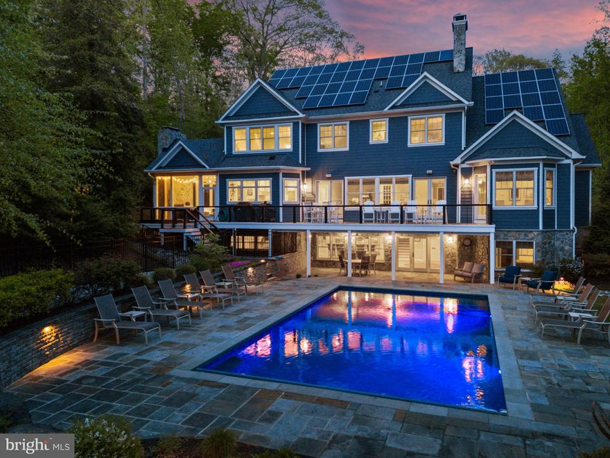 Stunning coastal waterfront home with pool has everything you are looking for in a forever home! Experience peace of mind whether home or away while residing in this gated property featuring 8600+ sqft across 3 sprawling floors with one level living option providing flexibility and luxury living at its best! The combination of low maintenance finishes, smart design and stunning interior architectural details offers the best of both worlds; comfortable living with all the modern conveniences to enjoy the everyday AND generously sized spaces both inside and out to accommodate gatherings of all sizes. The screened porch with wood-burning fireplace and pizza oven adjacent to the expansive rear deck with recessed hot tub and the lower level patio with heated, saltwater swimming pool with automatic cover maximizes outdoor entertaining. A picturesque setting, elevated and nestled amongst the trees, while still optimizing waterfront living  with a private pier, boat lift and multiple slips on a protected creek with easy access to the South River and Chesapeake Bay. Custom built and constructed in 2016, it is evident that no expense was spared! This turn-key property features hardwood hickory floors, elaborate millwork, high-end finishes and tall ceilings throughout. The main level boasts a luxurious Primary suite with vaulted ceiling, pool view and spa-like bath with glass enclosed shower, bubbler tub for the ultimate in relaxation and double vanities for convenience. The deluxe Chefs Kitchen with island and high-end appliances, coffered ceiling Living room with fireplace, dining area, home office/bonus room, powder room and spacious guest room with ensuite bath highlight the elegance of this home.  The upper level is adorned with 4 additional bedrooms, 2 adjoined by shared bath, 1 with ensuite bath that also services the 4th bedroom, sitting area and the fabulous oversized playroom/bonus room. The lower level is devoted to fun and leisure with a fully-equipped bar with seating, rec room area with fireplace, gym, and private guest room with ensuite bath. This property is located in the South River school district and it is the ideal location for quickly accessing the South River or Chesapeake Bay by boat, heading by car to Historic Annapolis or hopping on Rt. 50 to get back to Washington, DC. Escape to this waterfront oasis on Gingerville Creek!  Welcome Home!