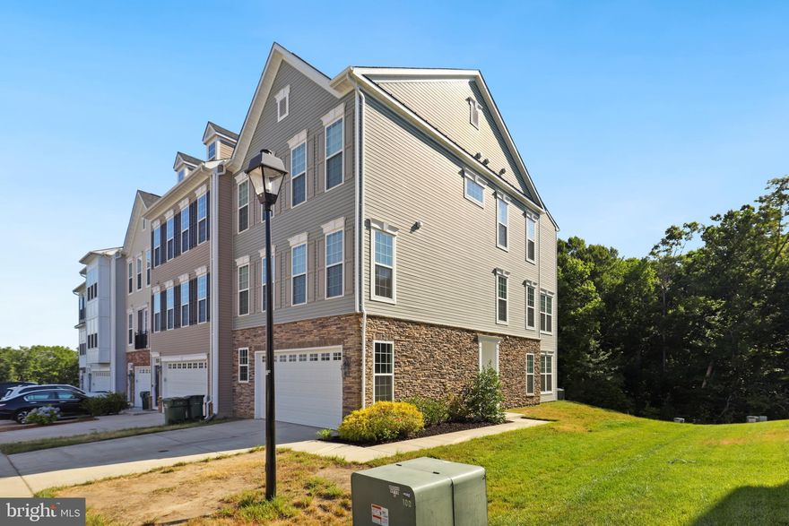 Welcome home to this gorgeous, end-unit townhome in the sought after Courtyards at Colonial Forge community. You are first greeted by the elegant stone craftsmanship at the front and side of this modern townhome, with side entry. Just five years old, this three level townhome boasts 2700+ finished square feet, an open floor plan, tons of natural light, and the added bonus of a three level bump out. The entry level is beyond spacious and has made for a great rec room area with it's bump out and also has a convenient half bathroom located here. The main level will really make you appreciate the open floor plan. The kitchen welcomes you in with it's gleaming wood floors, recessed lighting, huge kitchen island that comfortably sits four, stainless steel appliances, upgraded cabinetry, pantry, and dining area. The kitchen flows into the family room where the entertainment and relaxation continues. Enjoy the modern, built-in fireplace in this generously sized family room. The bump out on this level has made for a great office with it's french doors for privacy. A half bathroom completes this level. Make your way upstairs to the three good size bedrooms including the spacious primary bedroom suite with an amazing sitting area overlooking the tree lined backyard, vaulted ceiling, ceiling fan, and an envious size walk-in closet. The beautiful attached primary bathroom has extra cabinetry, a huge walk-in shower, dual sinks, and tile flooring. The other two bedrooms both have ample closet space and ceiling fans with a nearby full bathroom. The convenient laundry area is located up here as well.  The homeowners have enjoyed the peace and quietness of their area, and that all three levels have gorgeous views of the trees behind their home that provides peace and privacy. It's just minutes away from nearby Garrisonville Rd, Publix, and ideal for commuting to Quantico, Ft. Belvoir, Pentagon, and Fredericksburg. And you are just a short drive to Colonial Forge High School. What a great opportunity!