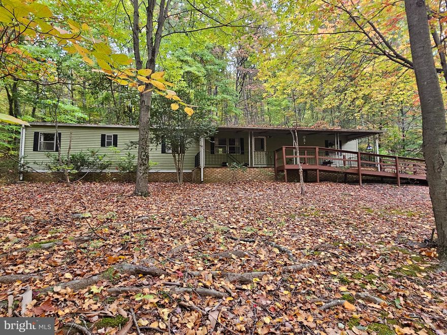 Close to Cacapon State park for recreational activities, short distance to Historic Berkeley Springs, this mostly wooded 6.64 acre parcel is unrestricted.  The older mobile home is livable while you build your dream home in the woods.  Property can be subdivided for several building lots.