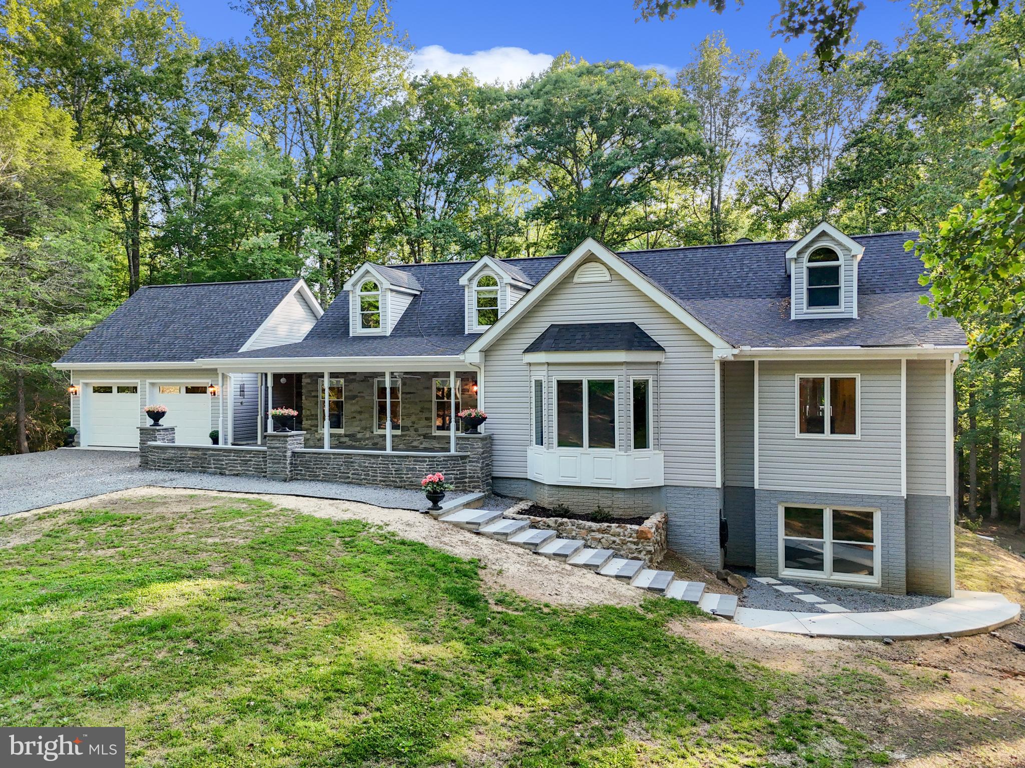 Welcome to 7006 Tapps Ford Rd, Amissville VA – a fully renovated, riverfront retreat on 25 private wooded acres with 500+ ft of Rappahannock River frontage. Designed for multi-generational living, this estate offers luxury, privacy, and flexibility. ALL larger and mechanical items have been replaced in 2023.
Enjoy two spacious main-level owner’s suites—ideal for guests, aging-in-place, or extended family. The primary suite features vaulted ceilings, a private mini-split system, and a spa-style bath with quartz double vanity, soaking tub, and zero-threshold shower. Upstairs includes two additional bedrooms with dormer storage and a renovated full bath.
A walkout lower level under the new suite is roughed-in (electrical, plumbing and insulation completed) for a bedroom, bath, and closet with private entry and access to a 3rd garage—perfect for an in-law, au pair, or future rental.
The gourmet kitchen boasts KraftMaid cabinetry, quartz counters, showcase glass cabinets, under-cabinet lighting, and Frigidaire Gallery appliances. A large island anchors the space, with a triple window over the sink overlooking the backyard- this kitchen is designed for the details; additional prep sink in the island, pop up electrical charging stations, appliance garage, wine storage and pull out drawers in the cabinets, and easy access to the screened in porch.
Step into the outdoors from the screened porch with a double-sided stone fireplace, adjoining sun deck, or handcrafted paver patio connecting the 2-car garage via breezeway. The inviting front porch adds charm and functionality.
FULLY remodeled in 2023, this home underwent a top-to-bottom transformation—featuring all-new bathrooms (3.5), trim, flooring, paint, a stunning kitchen with upgraded appliances, and the addition of a spacious main-level owner’s suite, new 2-car garage, separate 3rd garage, and a screened-in porch. No detail was overlooked: designer tile and quartz selections, zero-threshold glass shower, custom-stained stair treads, lighted closets, dual gas log fireplaces, 3 sets of French doors to the patio and deck, large windows in the new garage letting in tons of light, added Generac generator, replaced ALL major mechanical systems and exceptional curb appeal with a paver front patio and paver steps leading to the additional living space.
Just minutes to Orlean Market and I-66 (Markham exit), this turnkey riverfront sanctuary is ready for your next chapter. Schedule your private tour today!