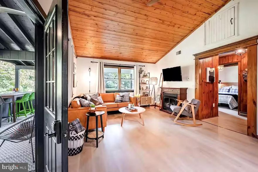 New-renovated, raised cabin with over 100 feet of river frontage!  This 3-bedroom, 1-bath retreat is the ideal escape as a vacation home, or full-time residence. Inside, the home features tall wood plank ceilings throughout, luxury vinyl floors, an open living area, and an updated kitchen.  Step outside and enjoy the spacious covered porch and patio area — ideal for grilling, dining, or simply soaking in the natural beauty of your large open yard. For added entertainment, the direct river access invites you to enjoy fishing, kayaking, or simply relaxing by the water.  The owner made significant upgrades to the property in the past 3 years, including a new septic, well head, water heater, gas fireplace, kitchen appliances, deck, & screened-in porch  – and a few years earlier, a new roof (2017) and central heat/AC (2019).  As a vacation rental, it has generated $52,000 over the past 15 months, and can come with an existing property manager and cleaner.  All furniture & furnishings (except pool table) optional, available for purchase.  See seller docs for a summary of rental history and financials.  $1,000 buyer credit if you continue using the same property manager.