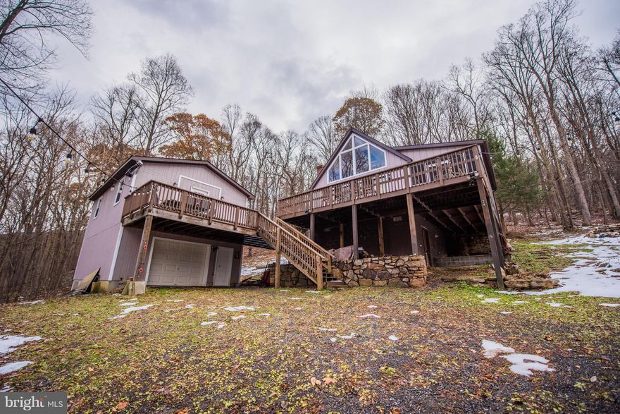 Updated Chalet home w/ a two-story 28x20 garage on 4.35 acres w/ MT views. Upper level of garage finished for additional living space. Lots of natural lighting in living rm w/ cathedral ceiling, updated kitchen, dinning area, one bedrm on main level, updated  bathrm, loft  bedrm and basement. Large decks connect garage and house. Common area on the Cacapon River for fishing, swimming and tubing.