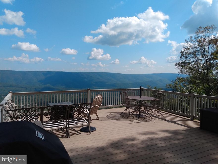 An Eagles View! If you have been searching for a Spectacular View  here it is!  What a fantastic way to start your day with this east, south easterly vista, the sun will peak over the Cacapon Mountain to greet you, and the ever changing conditions will always provide a fresh  picture of the area for your enjoyment.
This well kept 3 bedroom 1.5 bath Chalet is ready now and offers a recent metal roof, central air and heat, main floor laundry, insulated windows, and insulated siding.  A woodstove and high natural pine ceiling give a nice warm effect on the interior. The huge window wall allows you to take in the view without stepping outside but if you do, then the Trex front deck will provide such a vantage point you'll feel as if you're floating on air! The screened side porch is always nice for relaxing and taking in the local wildlife. If you just want to sit on a covered front porch it has one of those too!
The outdoor area doesn't go without the niceties either, this property has over 8 acres of beautiful WV mountain land improved with a very well built 1 car garage with electric and a high pitched roof that's handy for storage, outdoor stone oven, stone fountain and garden areas, but the natural stone formations will blow you away!
Near both the Cacapon and Potomac rivers and the Wildlife Management Area for all your extended outdoor activities, and Berkeley Springs for restaurants, shopping, spas and entertainment. This is one property you'll want to see now before it's too late! Professional Photos On The Way!