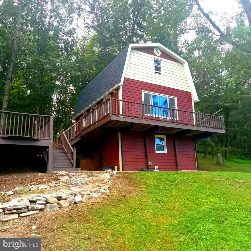 This is an excellent chance to own a charming chalet in Jefferson County WV's picturesque Hidden River area. The home features two bedrooms and one bathroom, offering the perfect blend of city convenience and country living. The kitchen has been updated with a new stove, microwave, and refrigerator. The property overlooks beautiful trees and the scenic Opequon Creek, set on a spacious one-acre lot that provides plenty of privacy.
The house is move-in ready, boasting upgrades like a new architectural roof and two HVAC mini splits. There's a partially finished walkout basement, ideal for watching TV while handling laundry. Another highlight is the large two-car garage, which offers ample storage and includes a shower downstairs—perfect after a day working on projects. Above the garage, you’ll find a separate one-bedroom, one-bath apartment with a kitchenette and its own entrance, suitable for guests or as a rental unit.