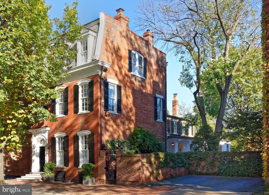 A true Old Town gem, this historic, fully-detached house built in 1880 by William McKnight sits on a prime double lot and has undergone an impeccable top-to-bottom renovation by its current owners. From the kitchen and breakfast room to all the bathrooms, to new rear windows and doors, every detail has been thoughtfully redone and executed to maintain charm and optimize modern allure. The stately Second Empire brick exterior and wonderful outdoor oasis with a covered porch, unusually large yard with a private patio and grassy lawn, and lush gardens brimming with mature trees, English boxwoods, camellias and roses takes this one-of-a-kind beauty over the top!  208-210 South Saint Asaph Street exudes warmth and sophistication inside as well, boasting airy 10' 6" ceiling heights in the entry and living room/parlor, plus many original features retained and restored such as an original transom over the front door, original entryway, original moldings and millwork, original staircase, and painted white Bunny Mellon-style floors enhancing the incredible character.  Entertaining and daily living are comfortably accommodated in the home's generously-sized rooms, offering a gracious backdrop of refined elegance. The spacious, airy living room featuring tall windows, a wood-burning fireplace with gorgeous marble mantle, and expansive seating areas affords charm and comfort when hosting guests. Nearby is a custom built-in serving breakfront with a wine cooler for easy serving and door to the covered porch for cocktails. The seamless flow continues into the regal dining room with its own wood-burning fireplace and access to the porch.  The chef will enjoy creating meals in the sparkling white and stainless steel contemporary kitchen appointed with a premium Wolf range, 2 Wolf ovens, 2 Fisher & Paykel dishwashers, and Subzero refrigerator. The adjoining open breakfast room is perfect for casual fare, brightened by floor-to-ceiling windows and a glass-paneled door leading outside.  Just as fabulous is the huge 25'-long family room with a wall of built-in bookshelves, and 6 windows overlooking the expansive yard and old antique brick patio.   Two staircases ascend to the upper floors, with windows bringing sunshine in on every level. The master suite is very sizable and divine, with high ceilings, light pouring in from 5 windows, an adjacent sitting room or possible 5th bedroom, numerous closets with jib doors, and a luxurious en-suite marble bath. Guest bedrooms are as inviting and lovely, with ample closets and renovated baths.  Best of all is the superior location on one of Old Town's most enchanting, coveted streets, in a desirable neighborhood that mingles cobblestoned blocks and timeless architecture with upscale shops and restaurants, rich culture, and iconic urban attractions.