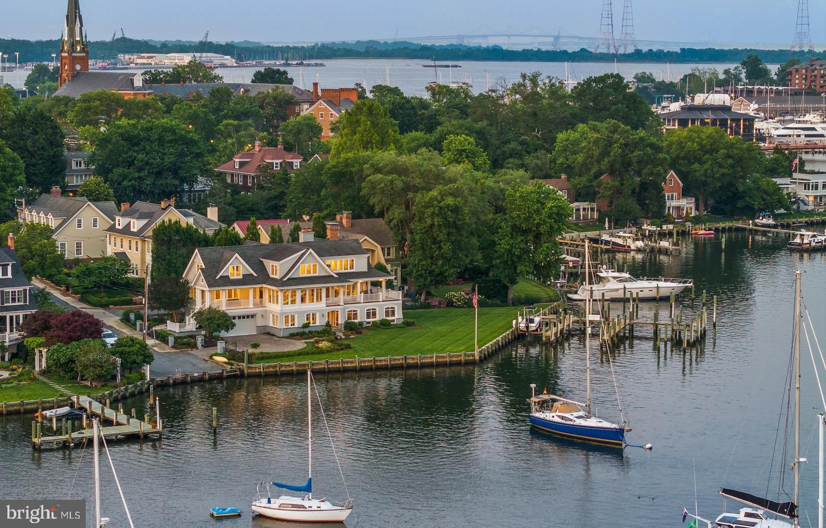 Welcome to the ultimate Spa Creek waterfront oasis! Enjoy living in the heart of historic Downtown Annapolis with walkability to everything the area has to offer including just steps to restaurants and bars, annual parades/events, Annapolis Yacht club, St. Mary's school, and water taxi pick up location. Additionally, the property boasts the only gated waterfront residence in Historic Annapolis. Savor the sweeping south-facing views! This exceptional property offers an intimate connection to the vibrant life on Spa Creek, where you can take in the tantalizing sunsets from the elevated vantage point and front row seats to Blue Angels show, Christmas lights parade, and fireworks. Boasting 260 feet of prime waterfrontage, it features a commercial-grade private pier designed to accommodate a 70-foot yacht, two 40-foot vessels, and provides a convenient boat lift and floating dock for launching additional water toys. This exceptional waterfront residence offers an unparalleled blend of refined luxury and architectural grandeur. From the moment you enter this timeless home, you are enveloped in natural light streaming through walls of windows that frame sweeping water views and span the main level, encompassing the living room, dining room, and grand entry. Step out onto the wraparound deck that seamlessly connects indoor and outdoor living —an ideal vantage point to savor the ever-changing vistas of Spa Creek. A thoughtfully appointed kitchen offers high-end finishes, and a conveniently located butler’s pantry, making both intimate meals and large-scale entertaining effortless. An elevator accesses all three levels, ensuring comfort and convenience throughout. The main level also features a newly renovated powder room and a private office space with endless water views, perfect for today’s work-from-home lifestyle. Anchoring the home is a dramatic architectural staircase, a sculptural centerpiece that guides you to the private upper level or the expansive lower level. Upstairs, the Primary Suite is nothing short of magnificent—an expansive retreat with panoramic water views, a private balcony, fireplace, and a luxurious layout that includes two spa-inspired bathrooms and two generous walk-in closets. An additional large guest suite also graces this level, complete with an ensuite bath and serene water views. The lower level is a haven for entertaining, with two ensuite bedrooms, a spacious family or recreation room, and a stunning custom wood bar complete with additional adjacent nautical cabinetry with wine refrigerators. The perfect set up for hosting family and friends. The pièce de résistance is the screened porch with panoramic views, grounded by a rich slate floor, and opening to a lushly landscaped yard that rolls gently to the water's edge. This is not merely a home—it is an experience. A waterfront sanctuary where timeless elegance meets modern sophistication on one of Annapolis’ most coveted stretches of shoreline. Welcome Home!