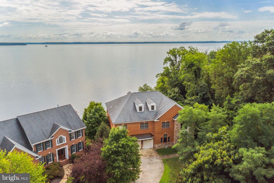 Beautiful River views from this custom 5 bedroom 5.5 bath home in the riverfront community of Featherstone Farms! A water and boat-lover's dream, the community has a private dock with multiple slips. The home itself is just steps from the Potomac River, with water views from every east-facing room. Walk into a grand two story foyer with curved staircase a marble floors. To your left is the living room with wood floors and crown molding.  Easily move into the stately 2 story family room with large windows facing the water and statement dual sided granite fireplace. Just on the other side of the fireplace is the dining room where the views on the water continue through bay windows. Crystal Chandelier, Coffered ceilings and wood floors complete the space. Enjoy cooking in the top of the line kitchen with gas cooktop, large French door built in sub 0 refrigerator, and dual wall oven. There is plenty of counter space for prep and cabinet space and pantry for storage. Start your mornings in the breakfast nook overlooking the water. A home office completes the first level. Access to the 2nd level is easy through the elevator or curved stairs. Retreat to the large primary suite with views of the water, sitting area, double sided fireplace, and spacious walk in closet. The en-suite features large ceramic soaking tub, glass stall shower and two vanities. Two large bedrooms with plush carpeting, closets and private en-suites and laundry room complete the level. The finished 4th level is perfect for game room/ teen room or guest space and includes a full bath. The water views continue down to the full lower level. Perfect for in-laws or an au-pair the space includes private laundry, 2nd full kitchen with full double door refrigerator with ice maker, gas cooktop and double wall ovens. A floor to ceiling dual sided fireplace separates the dining space and living room space. The 5th bedroom with walk in closet and  en-suite with stall shower and soaking tub finish the space. Hosting parties has never been more grand then on the large deck overlooking the spacious green lawn and water. Located right next to Featherstone National Wildlife Refuge, you will never have to worry about a second neighbor.  The neighborhood is surrounded by a multitude of activities - go hiking at one of the National Wildlife Refuges trails, play sports at Veteran's Park, go shopping at Potomac Town Center, or take the VRE into the city. Your dream lifestyle awaits in this home!