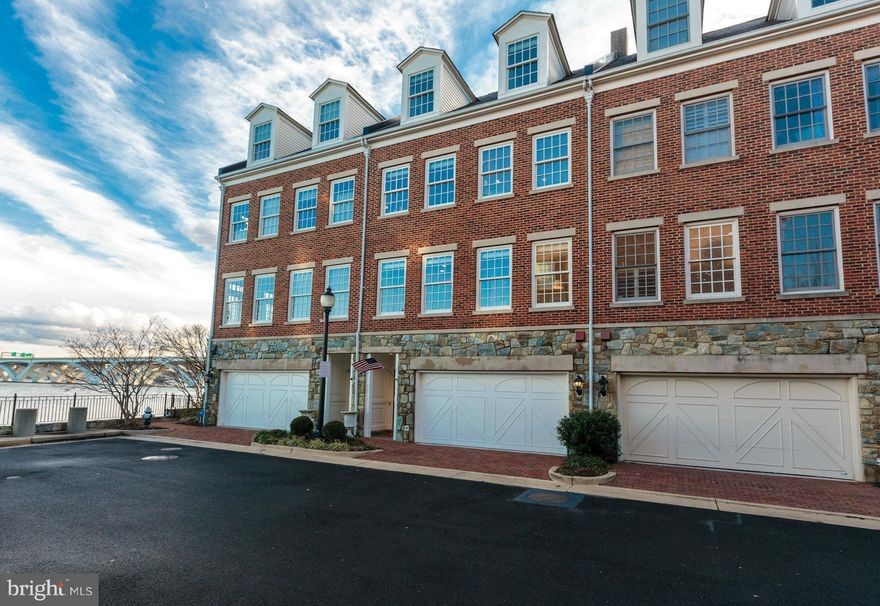 Overlooking the Potomac River, this elegant brick townhouse in Ford's Landing features an open layout, hardwood floors, 3 fireplaces, and countless upgrades throughout. 2 Juliet balconies, a rear brick terrace, and 2-car-garage. Steps to the waterfront, Mount Vernon Trail, and Jones Point Park.