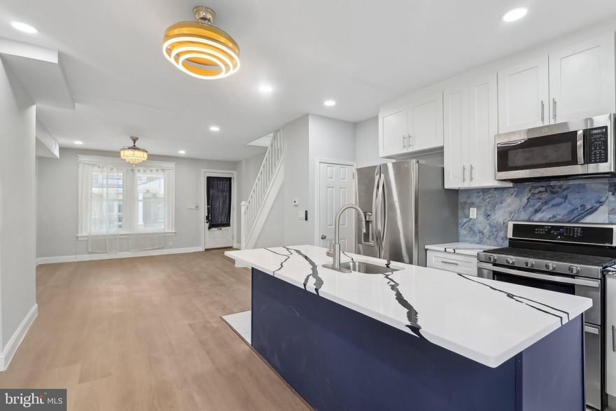 Welcome to this completely renovated rowhome, nestled on a quiet street in the Cobbs Creek neighborhood. Enter from the large, covered front porch into a bright and spacious open-concept main level that instantly feels like home. The cozy living room seamlessly flows into the stylish eat-in kitchen, complete with a dining area, a central island with seating, sleek stainless steel appliances, and gas cooking – perfect for entertaining and everyday living. A door off the kitchen leads to a private back patio, providing the ideal outdoor space for relaxation. Upstairs, you'll find three generously sized bedrooms, including a large front-facing primary bedroom with plenty of natural light. The full hall bathroom features beautiful tile work, a stall shower, and a skylight that fills the space with abundant natural light. The fully finished basement adds even more living space to this charming home. It includes a laundry room with a utility sink, a spacious recreation room for additional entertaining or relaxation, and another full bathroom. This home is ideally located near public transportation and a local park, ensuring easy access to everything you need. Don’t miss out on the opportunity to make this move-in-ready gem your own!