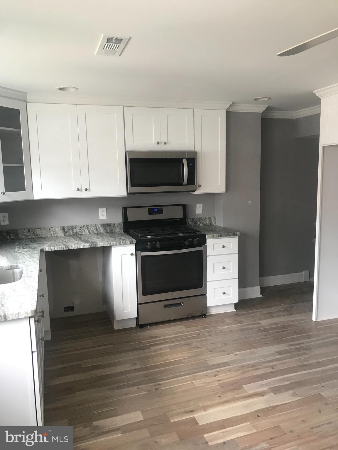 Newly rehabbed with new hardwood floors throughout, gorgeous kitchen with blanco shaker cabinets, granite countertops, 3 bedrooms, 2 bathroom, driveway, central air, and gas heat.
