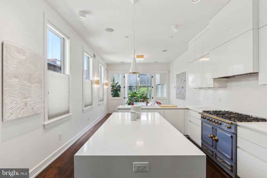 Nestled in the highly sought-after and desirable neighborhood of Hawthorne, this luxurious 3-story rowhome with a detached 2-car garage and separate apartment offers endless upgrades and two years remaining on the tax abatement. No expense has been spared to completely renovate this iconic home that is situated directly across the street from the tranquil Hawthorne Park. This home exudes authenticity from the curb. Upon entering, you're greeted by 10' ceilings, a stunning brick wall and a living room/office with glass French doors and a cozy wood-burning stove. The main level also features an extraordinary mudroom with custom woodwork, including built-in cubbies, closets, and shoe racks, along with a full hall bathroom and a back bedroom that serves perfectly as a guest suite. This room leads out to a huge private garden oasis. The second level featuring the showstopping all-white kitchen is a chef's dream, boasting an oversized island, custom Poggenpohl cabinets, a 43" La Cornue dual oven, Subzero Fridge, and high-end lighting fixtures and finishes. The adjacent dining room offers ample space for a table of 8 or more, while French doors lead to a cozy sunroom with a built-in BBQ grill, perfect for year-round entertaining. The grand family room is anchored by an exposed brick wall, accent built-ins, indoor swing, and a gas fireplace, creating a warm and inviting space for all. On the third level, the primary bedroom continues the theme of luxury with its own exposed brick wall, 18' vaulted ceiling, separate HVAC system, walk-in closet, and an ensuite bathroom featuring heated floors and an instant hot seamless shower. Two additional well-sized bedrooms with walk-in closets share a beautifully designed full bathroom with another seamless shower and separate soaking tub, laundry chute and heated flooring. Ascend to the rooftop terrace, where you're greeted by a rare sight, a residential green roof which creates an idyllic oasis, complete with a covered pergola for sun and rain protection, a sitting area with a gas fireplace, a wet bar with a fridge, and a weather proof Samsung "The Terrace" TV, all surrounded by panoramic city views for relaxation. Sunrises and sunsets can be seen throughout every window in the house; however, they are exceptionally stunning on the roof garden spaces. The fully finished basement is a true standout, featuring extra-high ceilings, radiant hot water flooring, and a laundry room with a convenient laundry chute. The kitchenette, complete with cabinets, a sink, and a fridge, is ideal for multi-functional use, while the massive storage area, exercise room, and a 700-bottle wine cellar provide ultimate comfort and versatility. Continue out the back door to a private patio with professional landscaping, including landscape lighting, a drip irrigation system, and a fountain, all leading to a detached 2-car garage, ensuring parking is never an issue. Above the garage is a 400-square-foot one-bedroom apartment, perfect as an au pair suite, guest quarters or as a fully permitted rental property. This apartment features its own kitchen, washer/dryer combo, full bathroom with a seamless shower, and ample living space. It is a truly unique space as special as the main home and shares no walls with any other building! Additional luxury features throughout the home include 1840’s-1850’s Cherry hardwood flooring throughout. The smart home elements include Lutron lighting with automation, professional Wi-Fi routers on all levels, Cat 5 connections in every room, a whole home speaker system with mobile app connect, and a full security camera system. Located away from the hustle and bustle of the city yet just blocks from every major area that Philadelphia has to offer. Not to mention only blocks from the Italian Market and 5 grocery stores for convenience. This home is the perfect blend of tranquility and urban luxury -- if you want to live in a truly unique, and special home, this is the one!