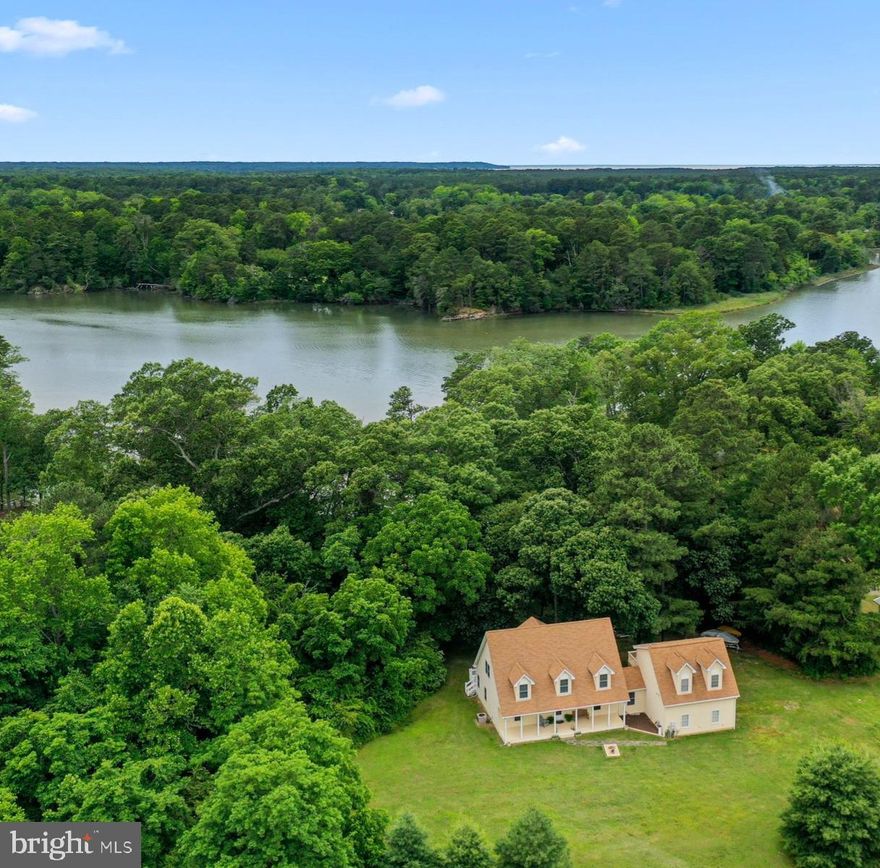 Private waterfront retreat on 5.9 acres with soaring water views, fabulous sunsets, and protected natural surroundings. Tucked away in a peaceful setting, this property offers a rare combination of privacy, acreage, and flexibility. The dramatic wall of glass in the family room brings in beautiful natural light and frames the waterfront beyond, while sunrise greets the open land out front and sunset reflects across the water behind the home. There are 4 bedrooms  including a main-level primary suite, and a separate apartment ideal for guests, extended family, a home office, studio or rental. 9' ceilings and a cathedral ceiling in the family room add to the open feel, while the new gas radiant heat unit provides comfortable warmth without the dry feel of forced air. Outdoor living is easy with maintenance-free composite decking and vinyl railing across the back of the home. The 2-car garage with a 10' high door offers excellent space for boats, vehicles, storage, or hobbies. At the waterfront, there are no steps to access the pier, complete with 2 boat lifts, making it ideal for boating, fishing, and water sports, with quick access to the Potomac River. There is plenty of room for a future outbuilding, farmette or possible additional home. Adding to the sense of privacy, the property sits across from the Baliles Center at Hull Springs, protected in conservation, helping preserve the natural waterfront setting for years to come. Recently appraised at $725,000 and now offered at a compelling value.