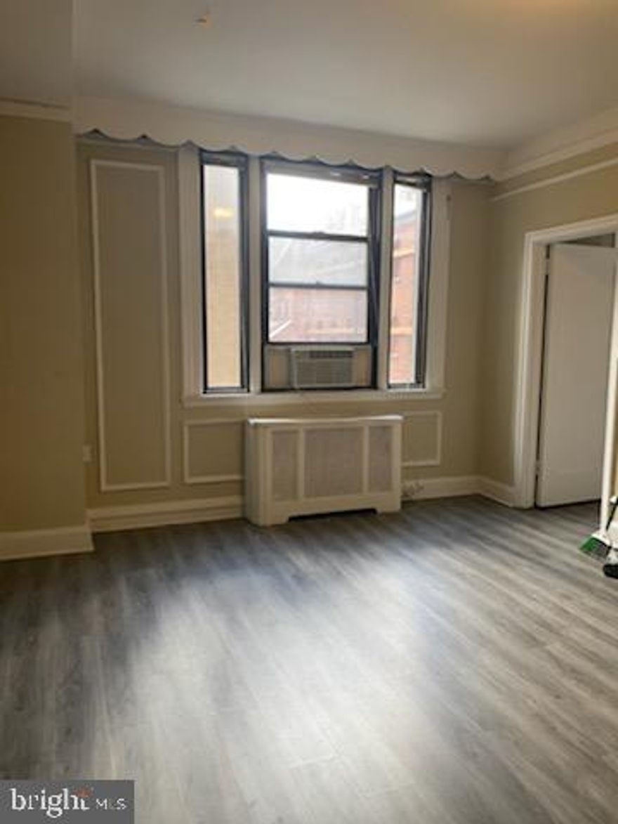 Enter The Carlyle, Unit 103 into a sun-drenched combined living and dining room with oversized windows and gray wood-like floors. Adjacent, there is a well-equipped and spacious kitchen with white cabinetry. Both bedrooms are generously sized and showcase great natural light. Bedroom 1 offers an ensuite bathroom and walk-in closet, while Bedroom 2 enjoys a nearby hall bathroom and large wall closet. Both baths offer shower/tub combinations.  The Carlyle is a pet-friendly, doorman building only one block from Rittenhouse Square. Rent includes the security of a 24-hour doorman and use of the building's state-of-the-art gym.