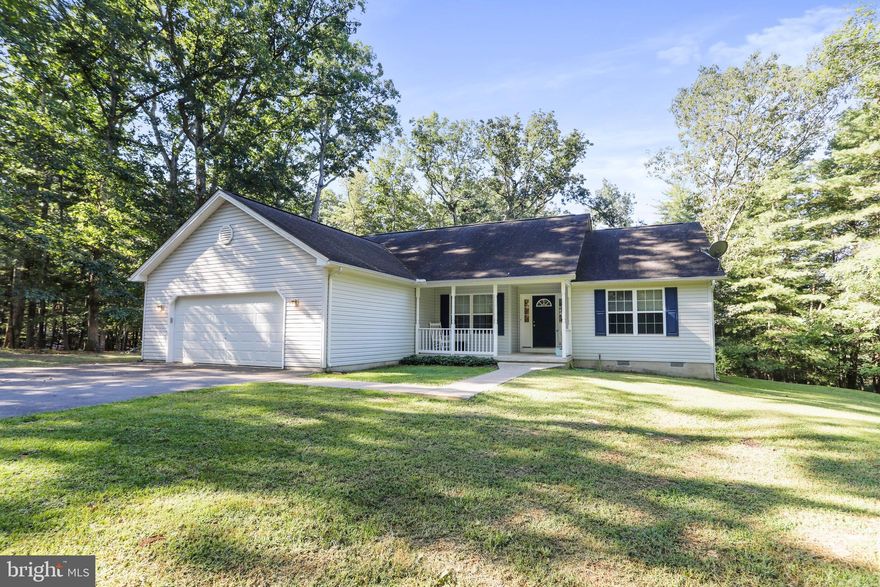 Settle into a peaceful rhythm of country living on more than five wooded acres in Berkeley Springs. This single level ranch is designed for everyday comfort and relaxed gatherings, starting with an open floor plan that brings the great room and kitchen together. The kitchen offers a breakfast bar and a bright bump out eating area that feels just right for slow mornings or casual meals. The luxury laminate flooring and fresh paint create a clean, inviting flow throughout the home. The split bedroom layout keeps the primary suite tucked away for privacy, and the direct access to the deck makes stepping outside for quiet moments feel natural. The bath includes both a soaking tub and a separate shower. A flexible den or office near the foyer lets you work from home or create a cozy reading space. Outdoors, the 16 by 23 deck overlooks a fenced yard framed by tall trees. Wildlife often wanders through, adding to the sense of privacy and simplicity. Evenings around the large firepit become part of the weekly routine when the stars come out. The oversized two car garage, extended driveway, and three year old HVAC system offer practical comfort.
This property provides a calm retreat while keeping you connected with easy drives to Berkeley Springs, Winchester, Martinsburg, and Hagerstown. It is a setting that makes space for both quiet living and convenient commuting.