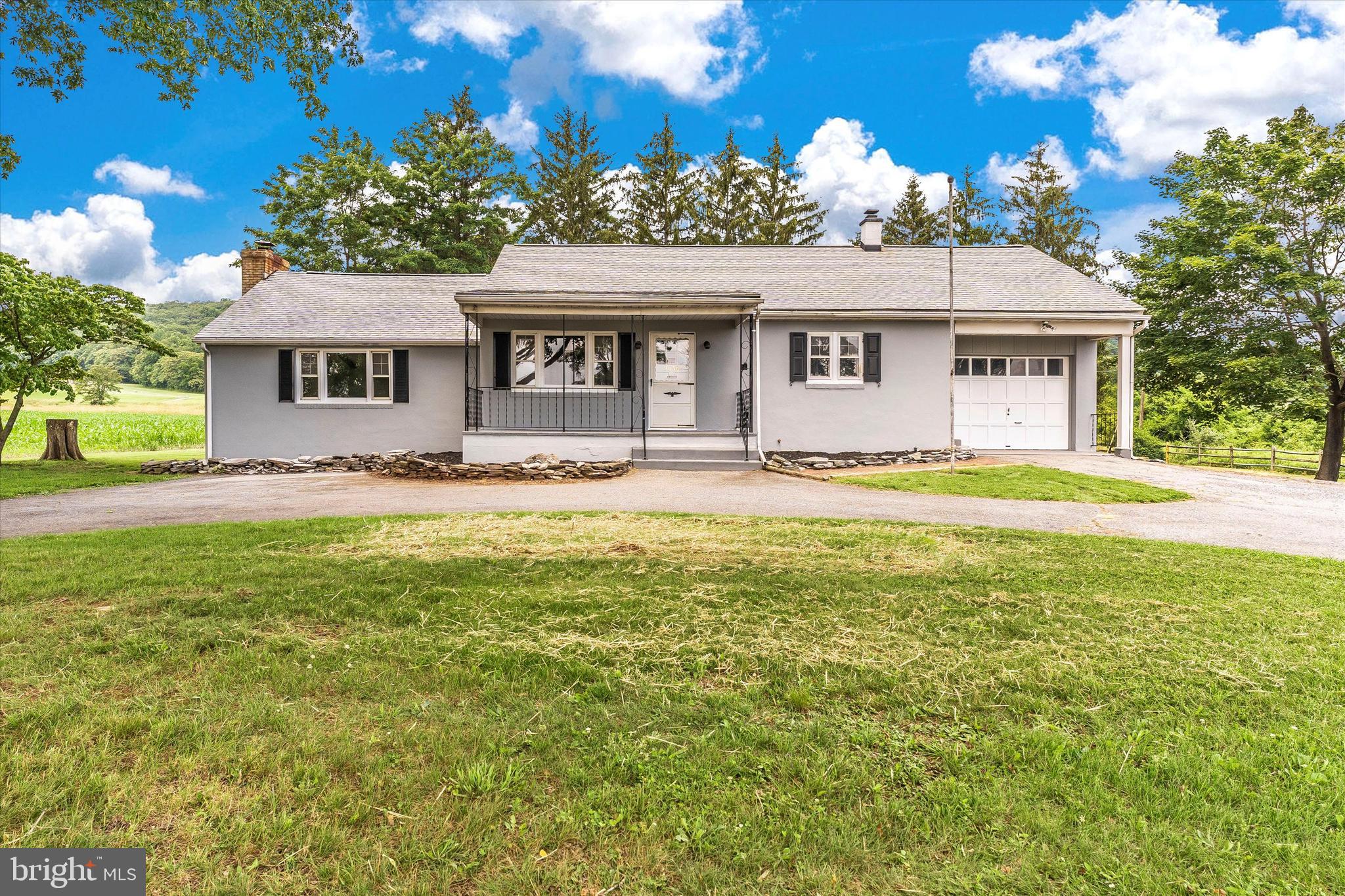 Enjoy the scenic mountain views and open space of this ranch style home located on a .68 acre lot surrounded by fields. This home has lots of parking with a circular driveway and a 1 car garage. Mature trees provide shade for enjoying the front porch for a relaxing evening. Large family room with brick fireplace and raised ceilings located off of dining room for entertaining and enjoyment. There is a kitchen with solid wood cabinets that leads to a spacious dining room. The first floor also features two bedrooms and one bath. There is a walk-up staircase to an open attic space which is 12 x 31 and may allow for future expansion. Other unique features include etched glass, solid wood doors and hardwood floors. Home has been freshly painted inside and out. This home also includes a full unfinished basement and walk-up additional storage space above the garage. No City Taxes or HOA here! Hurry! Don't Miss! Won't Last Long!