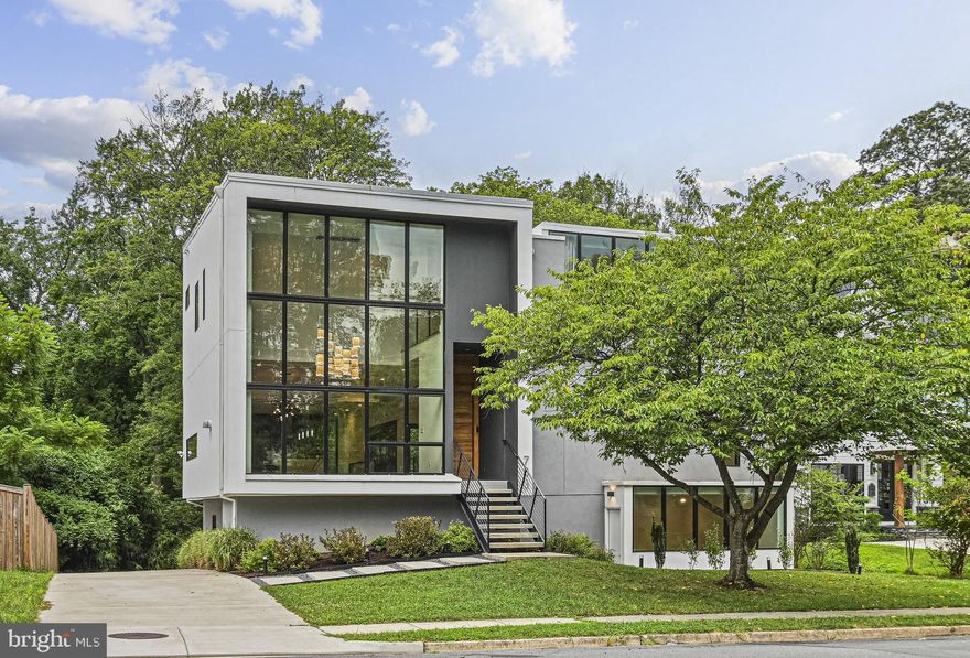 This unique property, known as "The Moment House", offers a blend of modern design, luxurious amenities, and a strong connection to nature. The house is designed to maximize natural light and create "special moments" with a light-filled, open floor plan and floor-to-ceiling windows. Developed by award winning designers at KOR.10 Architecture, Built in 2023, it features 7 bedrooms, Office, 5.5 bathrooms, 2 Car Garage and a spacious 5,650 sq ft interior over three levels .  Nature and daylight engage the home through balconies, decks, patios, and a luxury bathroom lofted above the landscape. Entertaining is made effortless and enjoyable: the kitchen is adorned with top-of-the-line appliances, quartz countertops and European cabinetry with details like built-in cutlery trays and skid free mats in drawers. Additional features include: 45” sink with touchless faucet, 3 side-by-side refrigerators integrated into the cabinets, a demonstration style island with a waterfall top, a counter replete with ice maker and sink serving the outdoor deck through a passthrough window. One level below: an expansive entertainment suite with wine bar and a walk out to the lower patio. The design balances social spaces with the need for peace and privacy: four bedrooms with two sharing the Jack & Jill bathroom, plus the fourth one with its own connected bath, a Primary Bedroom Suite with a dedicated Balcony and a bathroom that is focused on bringing calm and tranquility. A fitness room, an office/study, two guest suites, one with a walk-out cour anglaise all contribute to the need for focused activity and relaxation. Light, shade and shadow on honest natural materials like wood, steel, glass, and concrete are composed to create interest in every part of the house and together as a single composition. Clean lines hide the sophistication integrated into this house from the standpoint of thermal, heating and cooling, reuse and landfill reduction, storm water management and daylighting. Smart systems ingrained into the house make it both easy to use and functional. Great location in Vienna, within couple of miles of the Town of Vienna,  the historic W & OD Trail, Vienna Metro, Meadow Lane Park,  popular Mosaic District, the Tysons Galleria Mall, plus  Nottoway Park which has Basketball, Soccer, Baseball, Tennis, Volleyball courts, trails, Picnic Shelters.  Easy access to ramp for Route 66, Chain Bridge Road, Lee Highway, Vienna, Mosaic, Merrifield Restaurants,  Shopping. Open House this saturday 08/09/25 between 2pm - 4pm