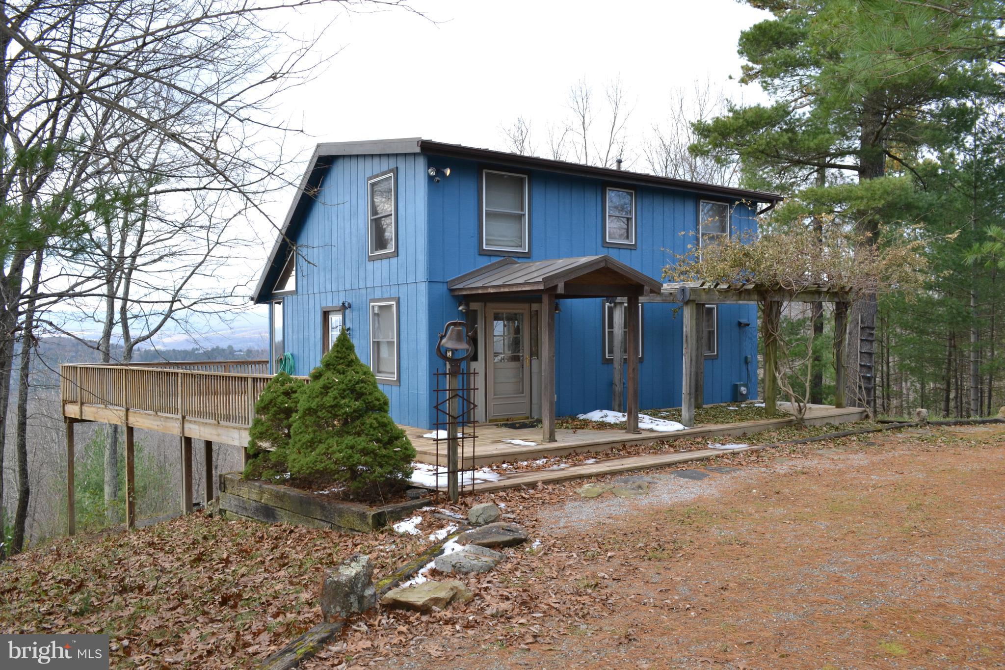 Moonshine Hollow is a gem perched above Mill Gap with outstanding views from every room. Whether you relax on the screened porch, on the deck or in the great room, the expansive views are breath taking. Offering 3 BDRM's and 2 1/2 BAs this home has a recent metal roof on both the house and detached garage. The two car garage offers plenty of space for a work bench and an unimproved second floor ready to be finished. The garage also comes with a wood burning stove. In the home the Galley Kitchen looks out onto the great room. Two bedrooms on the second level with accompanying bath. The finished lower lever features a master bedroom, private bath, wet bar, laundry room and large storage/office space. The home was recently stained so ready for the upcoming winter. Easily shown by appointment only.