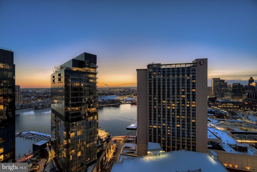 Perched high on the 27th floor of The Vue in Harbor East, this spectacular two-bedroom, one-and-a-half-bath residence delivers breathtaking panoramic views of the harbor, water, and Baltimore skyline. Floor-to-ceiling windows flood the open-concept living space with natural light, seamlessly connecting to a private balcony perfect for taking in the vistas. The chef’s kitchen is both stylish and functional, featuring a center island, sleek glass backsplash, and modern finishes ideal for everyday living and entertaining. The sun-filled primary suite offers expansive windows, dual closets, and a spa-inspired bath with double vanity and glass-enclosed shower. A versatile second bedroom with custom built-ins functions beautifully as a guest room, den, or home office. One covered garage parking space conveys.  The Vue condominium is located in Baltimore's hottest neighborhood within steps to the finest restaurants, boutique shops, Whole Foods, Starbucks, the Inner Harbor, waterfront and nightlife. **The condo Fee** includes heat, AC, hot water, water, sewer, front desk staff, package acceptance, building maintenance, onsite management. Take the elevator to the outdoor green space on the 8th floor for some fresh air or walking the dog without leaving the security of the building. Take the elevator to level 2 to the MAC gym and Harbor East Cinemas. Conveniently located to I-83.