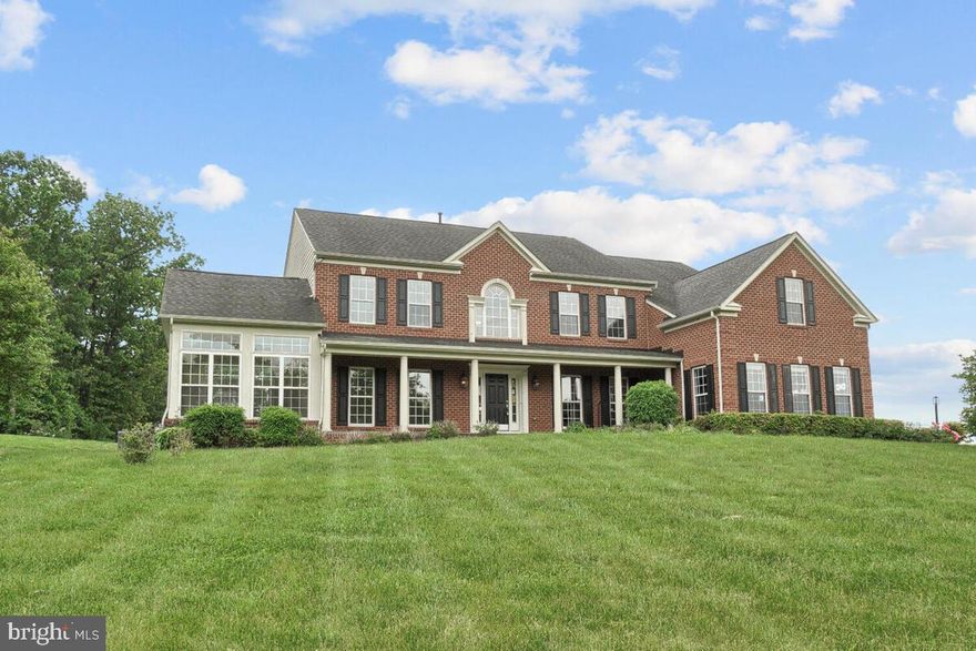 Your dream home awaits! Brick front, scenic setting, and an inviting slate covered front porch! Grand two-story foyer embellished with an intricate dual staircase and a stone accent wall, opposing formal living and dining rooms, solarium, large Butler's pantry, and a welcoming family room adorned with a stone profile wood burning fireplace. Top of the line granite counters in the kitchen and all bathrooms, hardwood floors on the main and upper level! Gorgeous kitchen highlights custom cabinetry, accent center- Island, prep sink, double gas stove, breakfast room, and an adjoining sunroom. Spacious owner's suite boasts a tray ceiling, sitting room, architectural columns, sitting room, and two walk-in closets.  Four vastly sized bedrooms with walk-in closets, dual entry bath, and en suite baths conclude the upper level. The lower level boast a beautiful stone wet bar, additional bedroom, full bath, and theatre room. Three-car garage with side access to home. Expansive deck overlooks an amazing view.