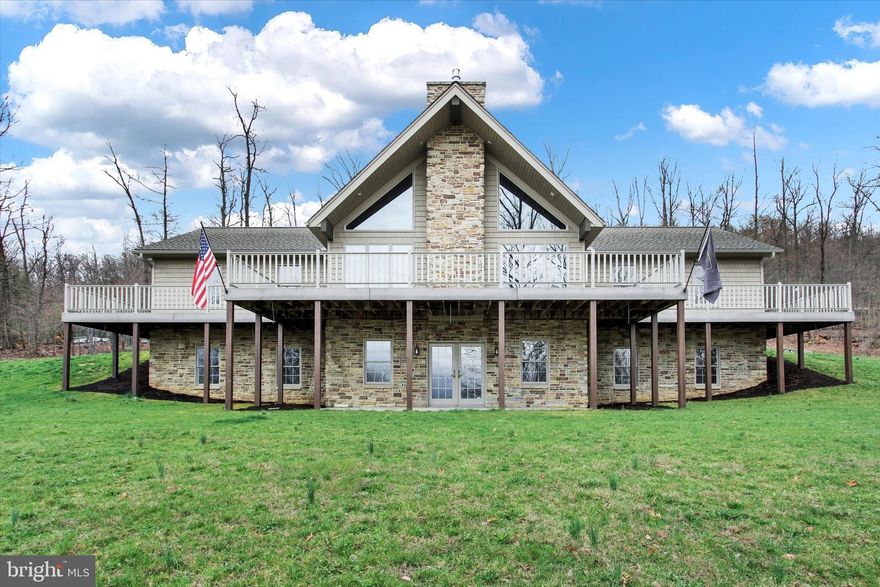 COUNTRY LIVING WITH CITY CONVENIENCE OF PUBLIC WATER AND SEWER. HILLTOP SETTING WITH A  WRAP AROUND FRONT & SIDE PORCH WITH AN OPEN WEST VIEW. HOME FEATURES A SPLIT LIVING PLAN WITH 3 BEDROOMS AND 2 BATHS. SPACIOUS EQUIPPED KITCHEN WITH ABUNDANCE OF COUNTER TOP AND CABINETS. COUNTY DINING AREA, SPACIOUS GREAT ROOM WITH VOLUME CEILING. FULL WALL STONE GAS FIREPLACE, HARDWOOD FLOORS. FULL WALK OUT BASEMENT WITH PARTIAL FINISH AND LOTS OF GLASS. CONCRETE BASEMENT WALLS . OVERSIZED 2 CAR GARAGE WITH STORAGE AREA. FIRST FLOOR EQUIPPED LAUNDRY ROOM OFF KITCHEN.  HEATING IS A HEAT PUMP WITH CENTRAL AIR AND PRESENT OWNERS USE AN OUTDOOR WOOD FURNACE. HOME WAS BUILT BY ROLAND HESS WITH HESS CUJSTOM CABINETS.