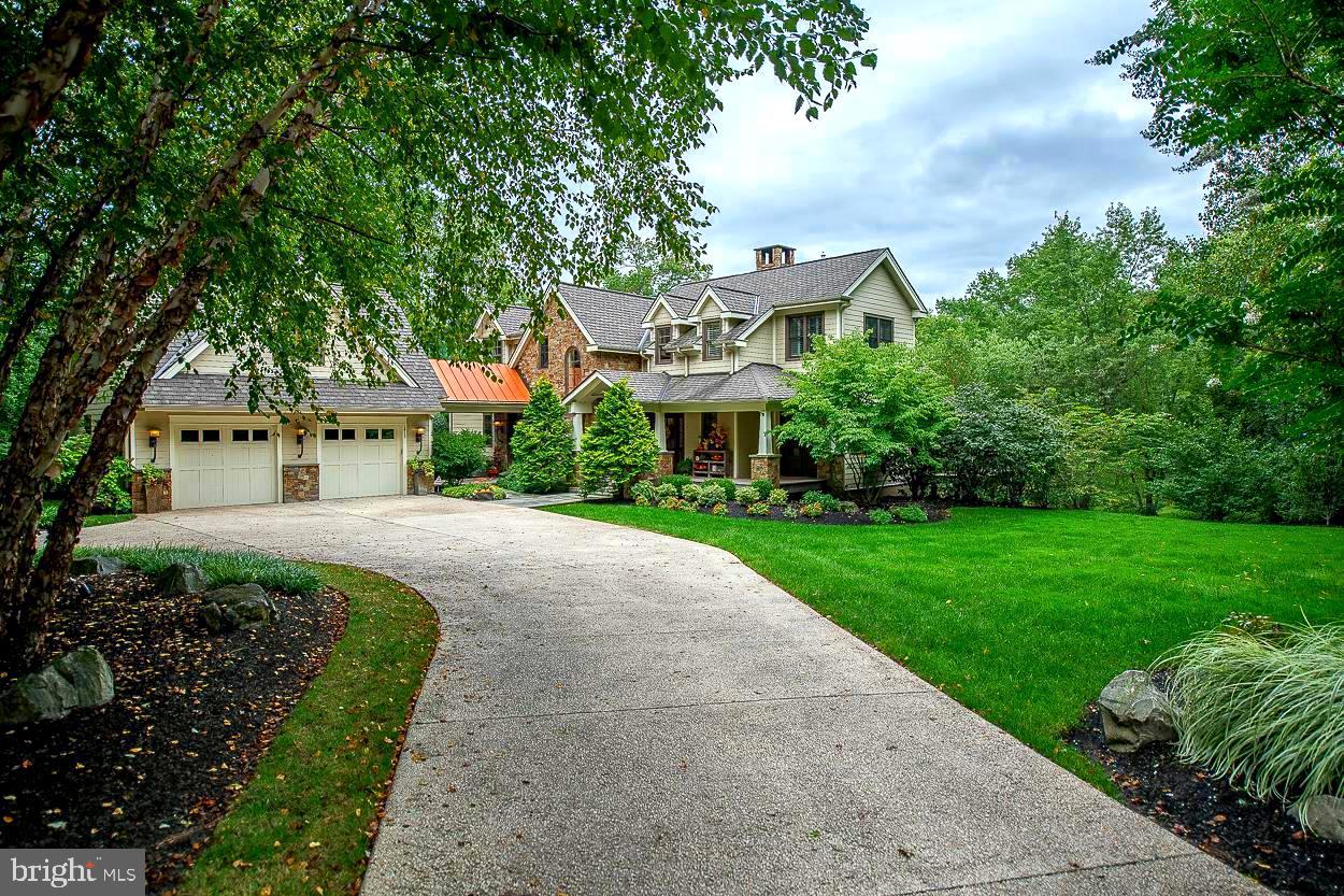 Set way off the road, perfectly nestled into nature- sits this custom boutique craftsman-style home that awaits the next incredibly fortunate buyer. Architect Rene Hoffman, along with the incredible design skills of the owner - created a truly unique home. The exterior-built from stone & Hardie plank - is warm & welcoming- it does not overwhelm you visually as you approach the house with grandeur- eventhough it is close to 6000 sf- the home is gracefully placed on the lot so not to overpower the trees, lawn, stream & pond that surrounds it- but-once you enter-the details & use of space is just spectacular. Walk through the covered porch & gracious front door, the 1st thing you see is the centerpiece of this custom design -a four-sided stone gas fireplace that can be viewed from almost every vantage point on the main floor- your family & guests will see a fire-glowing as soon as they enter. Continue to your right & the dining room -which already has tons of natural light- gets to enjoy the 2nd view of the fireplace , on the next side is the two-story family room offering access to one of the decks & showing off the 3rd vantage point of the fireplace. Look up to see salvaged beams & a warm wooden ceiling- it feels like you're on vacation everyday. The 4th side of the fireplace faces the gourmet kitchen. This open-concept cooking haven has island seating, a built-in banquette for morning coffee, and cabinetry & counter-top selections that withstand the test of time & will work w/ any style-trend, from contemporary to traditional. Off the kitchen is access to the 2nd deck, which looks over the fire pit, pond & so many lovely large growth trees. Also on the main level is a custom entertainment bar, great for setting up hors d'oeuvres, greeting & serving your guests & just simply, an easy spot to meet more storage needs. The last amazing space on this level is the master suite. Consisting of a dream bathroom, walk-in closet w/ custom built-ins, built-in dresser drawers, a spa-like bedroom - large enough for a king bed & a sitting nook & most importantly, personal access to the deck, with the privacy on this lot, you can wander out in your robe & have breakfast-no one can get a peek at you. Finally, this floor has a laundry rm w/ a pocket door closure & a powder room that will trap most of your guests inside, checking out all the cool details & special touches. Head to the 2nd floor & you'll find an open loft area currently set up w/a piano, an office space & built-in bookcases. This space is just so versatile! The 2nd level also has two more spacious bedrooms w/access to their own full baths- so when family & friends visit they'll have their own personal retreats. In one Br, the owner created a hidden napping closet for the grandkids -it can easily be converted back to a closet- it's just too cute. Head down to the lower level & you will find an open area designed as another living space/family room/playroom even though it is currently set up as a design center for the current owner's occupation- it has even more versatility than the loft on the 2nd level. Also on the ground floor is the 4th bedroom w/access to a full bathroom, great closet space & daylight views of the yard. This whole floor could be used as an In-law or guest suite, an office & exercise area, or just as a 4th bedroom & sitting area w/easy backyard access. The home has an 3+car over-sized garage w/a covered breezeway into the house. There is also a bonus unfinished space over the garage that could be turned into a 5th bedroom, art studio - again-quite versatile. The setting is the perfect balance of trees, lawn, pond & creek- not too much maintenance- but just enough to feel private & nestled. Sitting less than a mile from the Gwynedd Valley station, just a short walk to the Green Ribbon trail & only minutes from restaurants & shopping- you can own this hidden retreat near every convenience!