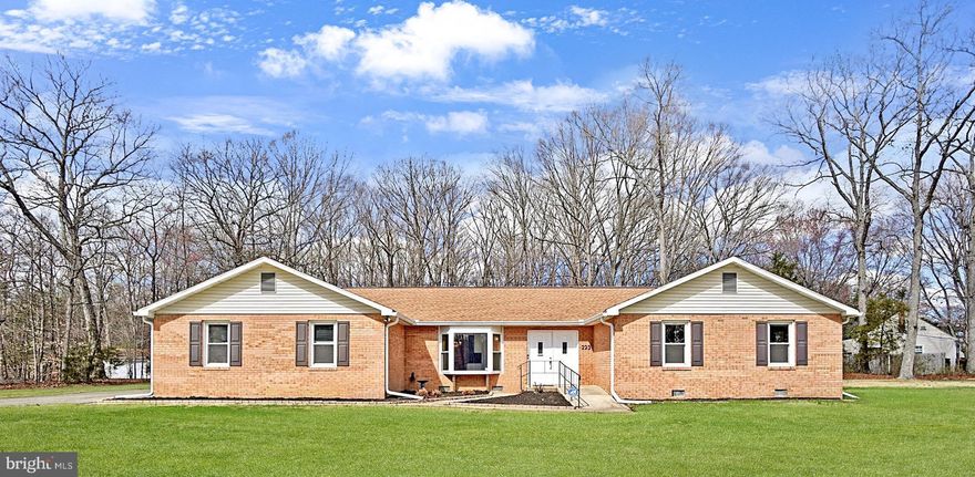 This elegant brick rambler is immaculate and offers one-level living at its best. Warm and bright throughout, the home features 4 generous bedrooms and 3.5 beautifully renovated bathrooms. Two primary suites each feature their own private en-suite, offering peaceful retreats for rest and relaxation. The second primary suite is especially versatile, ideal as an in-law suite, rentable space, home office, or recreation room. 

Designed with comfort and accessibility in mind, the home features numerous ADA-friendly elements, including a ramp and wide front entrance, widened interior doorways, spacious hallways for easy navigation, and a walk-in shower to enhance everyday convenience. 

The kitchen, fully updated with new cabinets and granite countertops, offers modern amenities, abundant workspace, and a charming window seat overlooking the front yard, perfect for spotting visiting wildlife. The bathrooms have also been tastefully renovated, adding a fresh and luxurious feel throughout. Elegant crown molding adds a refined finishing touch throughout the home.

 A cozy wood-burning fireplace anchors the family room, creating the perfect ambiance for relaxing evenings, or gathering with friends and family. Outside, a spacious detached garage and workshop provide excellent storage and the perfect space for DIY projects. An expansive deck spans the entire length of the back of the house. It can be accessed from either the living room or the primary suite and features a covered and screened in gazebo, an ideal setting, overlooking the serene, forested area behind the home, offering privacy and a peaceful natural backdrop, ideal for outdoor entertaining. Situated on a lovely corner lot, the .72 level acres offer endless opportunities for gardening, play, or simply enjoying the open space. 

With no HOA, you’ll have the freedom to personalize and enjoy your property as you wish. This home is move-in ready for the most discerning buyer and truly checks every box, style, accessibility, space, and setting. Don’t miss your chance to make this happy home yours!