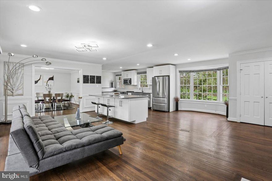 Discover 14400 Jones Lane, a beautifully designed modern split-level set on nearly 2.5 wooded and private acres in sought-after North Potomac - this is a home that truly must be experienced in person! Offering 3,566 square feet across three finished levels, this impressive home features five bedrooms and three full bathrooms. Defined by light-filled spaces, contemporary finishes, and a strong connection to the outdoors, the property combines comfortable living space with a striking natural setting. A gated drive, flagstone walkway, and double front doors welcome you into the residence, where hardwood floors, recessed lighting, high-end finishes, and an abundance of windows create a bright and inviting atmosphere. The back of the home is defined by walls of windows that flood the interior with natural light. The open main level living area centers around a gourmet kitchen with granite countertops, a large center island with breakfast bar, stainless steel appliances, a subway tile backsplash, and crisp white cabinetry. The kitchen flows into a breakfast area framed by a bay window and into a living room/sitting area with a dual-sided fireplace, large windows, and sliding glass doors opening to the deck. Adjacent to the kitchen, the formal dining room features wainscoting and a wall of windows with sliding glass door access to the deck. A private office with built-ins, a dual-sided fireplace, and another wall of windows with sliding glass door access provides additional flexibility and completes the main level. Outdoor living is a standout feature of the home. Spanning the length of the main level, the expansive deck creates an exceptional extension of the interior living space and includes a trellis and stone retaining wall that add character and definition. Multiple access points from the main level make it easy to enjoy the peaceful backyard setting, while the surrounding wooded acreage enhances the sense of privacy. Upstairs, the style and design continue for a cohesive look. The spacious primary suite offers an en-suite bath with a glass door shower and contemporary tile and finishes. Two additional bedrooms and a second full bath complete the upper level. Step down from the main level to the expansive lower level, which includes a fourth bedroom, full bath, dressing area, and a family room with a fireplace set within a stone accent mantel. Doors from both the family room and bedroom provide direct access to the patio and backyard, and a mudroom with outside access adds everyday convenience. A two-car detached garage provides exterior an extra storage room + a bonus lower level perfect for use as a wine cellar or cold storage.  This home offers a wonderful combination of space, design, comfort, and convenience, all within minutes of shopping, dining, entertainment, recreation, and major commuter routes. **Extensively pre-inspected with septic, well, water quality, radon, and full home inspection completed — providing buyers with confidence and transparency.**