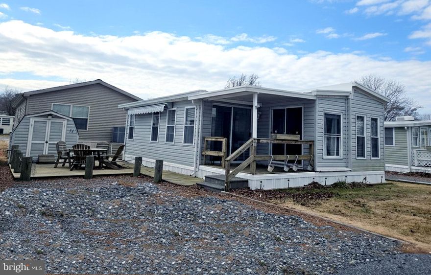 It's all about the location and the Sunsets.  Enjoy stunning sunsets w/ a peek of the river and an exceptional location in this charming mobile home, situated on one of the most desirable streets in White Horse Park. Just a short walk to the marina and dock and other amenities. This well maintained three bedroom, one bath beach retreat is ready for immediate enjoyment, with the added benefit of land ownership and no ground rent. The open living and kitchen area includes a full-size gas range and refrigerator with ice maker and dishwasher.  The home is being sold lightly furnished including 4 Mounted TV’s and features a separate laundry room with a washer and dryer. Newer HVAC included and newer indoor hot water heater. A durable metal roof with a 99 year warranty adds long term value.  Outdoor living is a highlight, with a spacious area ideal for entertaining, relaxing, or enjoying coastal traditions such as cookouts and crab feasts. A storage shed provides additional convenience. Residents enjoy access to boat storage for a nominal annual fee, a private boat ramp with trailer parking, and potential availability of a marina slip with water and electric (waiting list may apply). Community amenities include a swimming pool, playground, basketball court, community center with covered gazebo, free loaner bikes, boat and kayak storage, fish cleaning station, crabbing and fishing gazebo, and a secure gated entrance with 24 hour security.