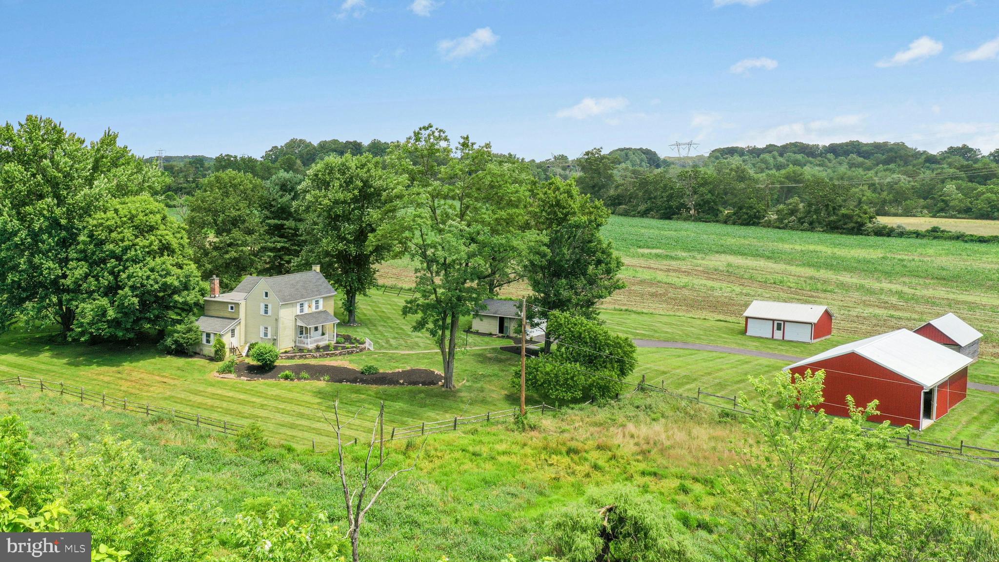 Resting atop a gentle hillside, Spring Creek Farm offers stunning long range views and a stately 1860 farmhouse on a peaceful country road. Lovingly preserved over the years by a single family, this charming farmstead has multiple outbuildings and more than 46 preserved acres waiting for a new caretaker.
A covered porch is the sweet introduction to this cozy home. The light and bright interior is punctuated by abundant windows, letting in a gentle breeze on even the warmest days. A spacious living room opens to a formal dining room, which in turns leads to a pergola-covered patio overlooking the side yard. The large kitchen, mudroom, and first floor laundry complete this level. Upstairs, four generously sized bedrooms share a hall bath, while a walk-up attic provides space for storage or expansion.
A large pole barn offers room for storage or hobbies, while two detached garages provide additional space for vehicles. Surrounded by expansive acreage, Spring Creek Farm is a captivating full-time residence or a scenic haven from city life.