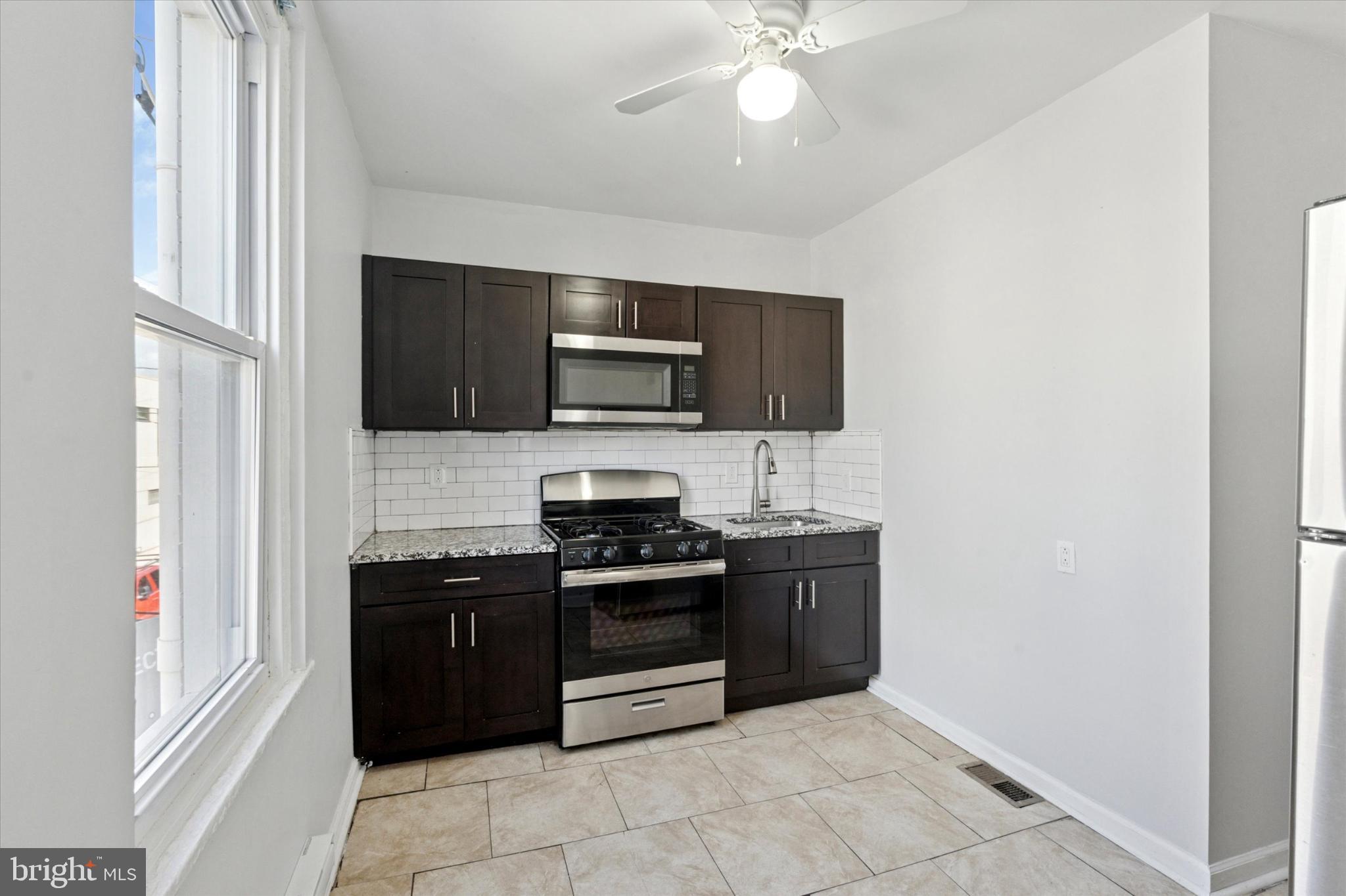 This second-floor apartment features two comfortable bedrooms and one full bathroom, presented in a bright and practical layout. The updated kitchen features granite countertops, stainless steel appliances, and plenty of cabinet space for storage. Large windows bring in natural light throughout, while carpeting in the living areas and bedrooms adds warmth. With tile in the kitchen and bath for easy upkeep and the privacy of an upper-floor location, this apartment provides both convenience and comfort.