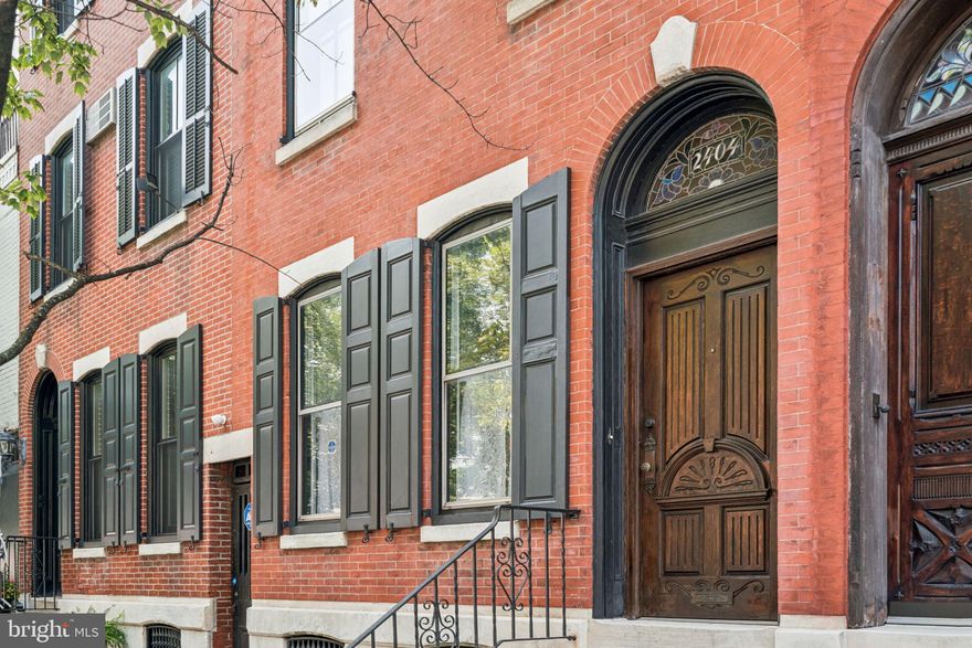 Your opportunity to own a grand red brick home with hand carved wood front door on a generous 17' x 78' lot one block from Fitler Square, a short walk to Schuylkill River Park, convenient to Rittenhouse and an easy commute to University City, Penn, CHOP and HUP. Greenfield school catchment. Admire the impressive facade, with black shutters on three floors, and the handsome wood door with transom as you enter into the tiled vestibule. Note the newly refinished hardwood floors. Large front windows. High ceilings. Elegant staircase. Beautiful marble fireplace mantel. Window on the side brings in light. Convenient first floor powder room. Separate dining room. Kitchen with plenty of counter space and cabinetry in need of cosmetic renovation. Mudroom with laundry leads to a private enclosed yard. Side alley to the street handy for trash and bikes. Up the stairs, 3 well proportioned bedrooms on the second floor with full tiled bathroom with tub/shower. Top floor boasts 2 bedrooms (one could be converted into a bathroom suite). Full basement for storage.  Note: 2025 system upgrades include a newer gas hot water heater, new central HVAC system with A/C and gas heater. 100 amp electrical service panel and breakers professionally installed in 2025. This is an estate. Make this well-loved historic home your own. Schedule a showing today!