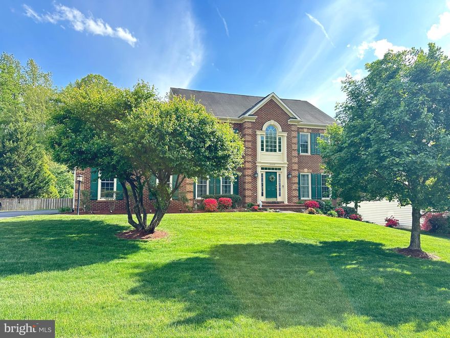 Welcome home to 12923 Champlain Drive nestled in the heart of Meadowbrook Woods, one of the most desirable neighborhoods in Manassas. This expansive NV Kingsmill model with 5 bedrooms and 5 bathrooms boasts over 5,000 finished sq ft with a backyard oasis will absolutely wow you! Hurry in to enjoy the pool all summer long! The backyard might just be one of the best in the neighborhood! It is expansive, flat, fully fenced and features an amazing stone outdoor kitchen, gorgeous, heated saltwater pool, raised jacuzzi spa with waterfall feature, pool deck, and covered patio with outdoor living room and TV that conveys. As you walk inside this beautiful brick front colonial your greeted with a two-story entry foyer flooded with natural light from a large Palladian window where you find freshly painted walls and trim, and new luxury vinyl plank flooring throughout. The main level floor plan can host a large crowd as well as multigenerational living with an optional main level bedroom (or large home office) off the family room. Around the corner there is a half bath and combined with the added full shower in the laundry room (on the same level) this creates a divided 5th full bathroom to accommodate a main level living situation or main level guest room. The formal dining and living room flank the entry foyer, and towards the rear of the house is a large family room with warm floor to ceiling stone hearth fireplace with natural gas logs. The family room is open concept and flows into the newly renovated kitchen. The kitchen has space for a large table and loads of new cabinetry with quartz counter tops, new appliances, and center island. Just past the kitchen is a mudroom that connects to the garage to your left and a separate laundry area with full shower to your right. Off the kitchen you will find a large deck. Upstairs houses a primary suite with a separate den or sitting area, large walk-in closet and a grand bathroom with soaking tub, separate shower, two sink vanities, and private toilet closet. As you walk down the hall you will find three more generous-sized bedrooms; one with an ensuite private bathroom and the other two rooms share a jack and jill bath. The lower level has a large recreation area, a second family room with gas fireplace, a kitchenette bar with refrigerator, sink, and dish washer, and an additional bedroom and a full bath that has been recently renovated. The basement has full windows along the back and a walk out French door to the patio with outdoor kitchen and pool spa area. Major recent upgrades include; new floors on main level 2025, renovated kitchen 2024, lower-level bathroom remodel 2024, all new windows 2022, new hot water heater 2023, new attic fan 2025, new pool heater 2025, new pool booster pump 2026, HVAC systems replaced in 2019.  Over $150,000 in recent upgrades and renovations!  It's nestled in a convenient mid-county location with easy access to I-95, I-66, Fairfax, DC, VRE train, as well as Quantico and Fort Belvoir. This home is a short drive to shopping & restaurants in the Historic City of Manassas, Town of Clifton, Woodbridge, Gainesville & several local Prince William and Fairfax County Parks. Meadowbrook Woods has an abundance of amenities and a vast community social calendar. Living here you feel a great sense of community and pride of ownership, all within the highly rated school tier of Marshall ES, Benton MS, and Colgan HS. The HOA amenities include a club house that can be reserved for parties and is equipped w/ a full kitchen, a large outdoor pool (lap lanes), kiddie pool, swim team, playground, basketball & tennis courts, pond, walking trails, open common areas, trash & recycling pick up. Come see your dream home and enjoy your own private pool and spa backyard oasis  just in time for summer!