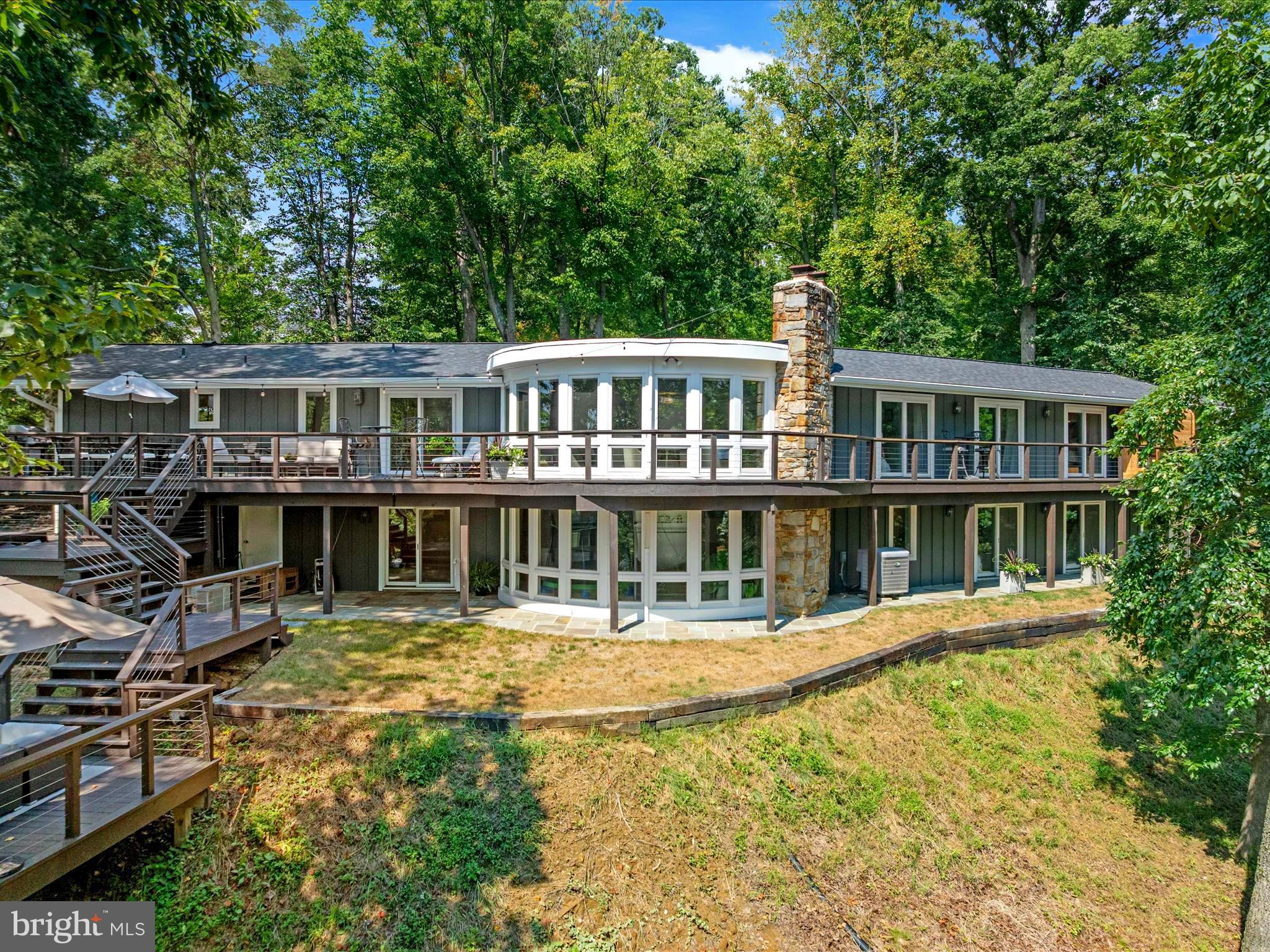 Exquisite South River Waterfront Estate
Coming Soon! Experience waterfront living at its finest in this rare South River estate situated at the end of a quiet cul-de-sac. Elevated above the water on a private 1.07-acre lot with 132 feet of premier frontage, this stunningly remodeled 4,900+ sq. ft. rancher offers timeless elegance, modern sophistication, and panoramic river views from nearly every room. The open-concept main level is designed for both grand entertaining and effortless everyday living. A luxurious primary suite features a spa-inspired bath, an expansive custom walk-in closet with laundry rough-in, private deck access, and a brand-new outdoor sauna overlooking the water. Two additional bedrooms and two fully remodeled baths complete the main level. At the heart of the home, the gourmet chef’s kitchen showcases a striking 6+ person island, six-burner gas stove, custom cabinetry, quartzite countertops, walk-in pantry, built-in wine fridge, and built-in microwave. The space flows seamlessly to wraparound decks and a six-person hot tub, creating the perfect setting for entertaining against a breathtaking waterfront backdrop. A stone fireplace anchors each level, highlighting spectacular river views. The walkout lower level offers three additional bedrooms and a full bath, each with sweeping river views and direct access to bluestone patios and hardscaped walkways. For boating enthusiasts, this property offers deep-water access, a 40,000 lb lift, 20,000 lb lift, 10,000 lb lift, two shore power hookups, and an additional slip accommodating a 40+ ft vessel. Just a one-minute boat ride takes you to the South River Slalom Course. The Bon Haven community enhances the lifestyle with a boat ramp, sandy beach, kayak storage, swing set, fire pit, private pier with slips, and a large waterfront gazebo for gatherings and events. The home has been meticulously updated, including the kitchen and baths, main-level hardwood floors, lower-level luxury vinyl plank, Hardie siding and new windows and doors (2 years), a 30-year architectural roof (1 year), all-new decking, extensive bluestone hardscaping, upgraded 400-amp electrical service, a new hot water heater (2 years), and a new driveway (6 months). This ideal location offers quick access to Routes 50 and 97 and is just minutes from Annapolis Town Center, Whole Foods, Safeway, Home Depot, and more. With commanding views, refined finishes, and world-class boating amenities, this South River estate is a true luxury retreat—an exceptional offering in one of the region’s most coveted waterfront communities.