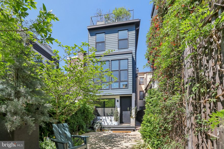 Nestled in the highly sought-after and desirable neighborhood of Hawthorne, this luxurious 3-story rowhome with a detached 2-car garage and separate apartment offers endless upgrades and two years remaining on the tax abatement. No expense has been spared to completely renovate this iconic home that is situated directly across the street from the tranquil Hawthorne Park. This home exudes authenticity from the curb. Upon entering, you're greeted by 10' ceilings, a stunning brick wall and a living room/office with glass French doors and a cozy wood-burning stove. The main level also features an extraordinary mudroom with custom woodwork, including built-in cubbies, closets, and shoe racks, along with a full hall bathroom and a back bedroom that serves perfectly as a guest suite. This room leads out to a huge private garden oasis. The second level featuring the showstopping all-white kitchen is a chef's dream, boasting an oversized island, custom Poggenpohl cabinets, a 43" La Cornue dual oven, Subzero Fridge, and high-end lighting fixtures and finishes. The adjacent dining room offers ample space for a table of 8 or more, while French doors lead to a cozy sunroom with a built-in BBQ grill, perfect for year-round entertaining. The grand family room is anchored by an exposed brick wall, accent built-ins, indoor swing, and a gas fireplace, creating a warm and inviting space for all. On the third level, the primary bedroom continues the theme of luxury with its own exposed brick wall, 18' vaulted ceiling, separate HVAC system, walk-in closet, and an ensuite bathroom featuring heated floors and an instant hot seamless shower. Two additional well-sized bedrooms with walk-in closets share a beautifully designed full bathroom with another seamless shower and separate soaking tub, laundry chute and heated flooring. Ascend to the rooftop terrace, where you're greeted by a rare sight, a residential green roof which creates an idyllic oasis, complete with a covered pergola for sun and rain protection, a sitting area with a gas fireplace, a wet bar with a fridge, and a weather proof Samsung "The Terrace" TV, all surrounded by panoramic city views for relaxation. Sunrises and sunsets can be seen throughout every window in the house; however, they are exceptionally stunning on the roof garden spaces. The fully finished basement is a true standout, featuring extra-high ceilings, radiant hot water flooring, and a laundry room with a convenient laundry chute. The kitchenette, complete with cabinets, a sink, and a fridge, is ideal for multi-functional use, while the massive storage area, exercise room, and a 700-bottle wine cellar provide ultimate comfort and versatility. Continue out the back door to a private patio with professional landscaping, including landscape lighting, a drip irrigation system, and a fountain, all leading to a detached 2-car garage, ensuring parking is never an issue. Above the garage is a 400-square-foot one-bedroom apartment, perfect as an au pair suite, guest quarters or as a fully permitted rental property. This apartment features its own kitchen, washer/dryer combo, full bathroom with a seamless shower, and ample living space. It is a truly unique space as special as the main home and shares no walls with any other building! Additional luxury features throughout the home include 1840’s-1850’s Cherry hardwood flooring throughout. The smart home elements include Lutron lighting with automation, professional Wi-Fi routers on all levels, Cat 5 connections in every room, a whole home speaker system with mobile app connect, and a full security camera system. Located away from the hustle and bustle of the city yet just blocks from every major area that Philadelphia has to offer. Not to mention only blocks from the Italian Market and 5 grocery stores for convenience. This home is the perfect blend of tranquility and urban luxury -- if you want to live in a truly unique, and special home, this is the one!
