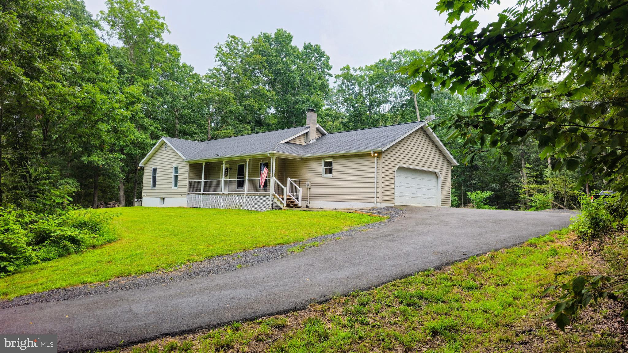 Providing a combination of convenience and privacy, this fully renovated 3 bedroom, 2 bathroom rancher sets quietly nestled on an unrestricted 1.5 acre lot along a popular commuter path. The home has been modernized with low-maintenance luxury plank flooring and a delightful kitchen that features stainless steel appliances, pull up bar seating, and upgraded granite countertop. The open floor plan includes a large living room and an adjoining dining room with sliding glass door that leads to the rear deck and yard. The owner's suite features a private bathroom with clean and modern fixtures, a stylish barn door, and a walk-in closet with built in shelving. Across the hallway, the second and third bedrooms share an updated guest bathroom. From the living room, an open stairway leads to the unfinished walkout basement with additional room for storage or future expansion and includes a wood stove and the laundry. The exterior of the single-story home features a side load garage and a beautiful sitting porch to enjoy the wooded surroundings. For added security, the home features an exterior security camera system with a large monitor in the kitchen for easy viewing.