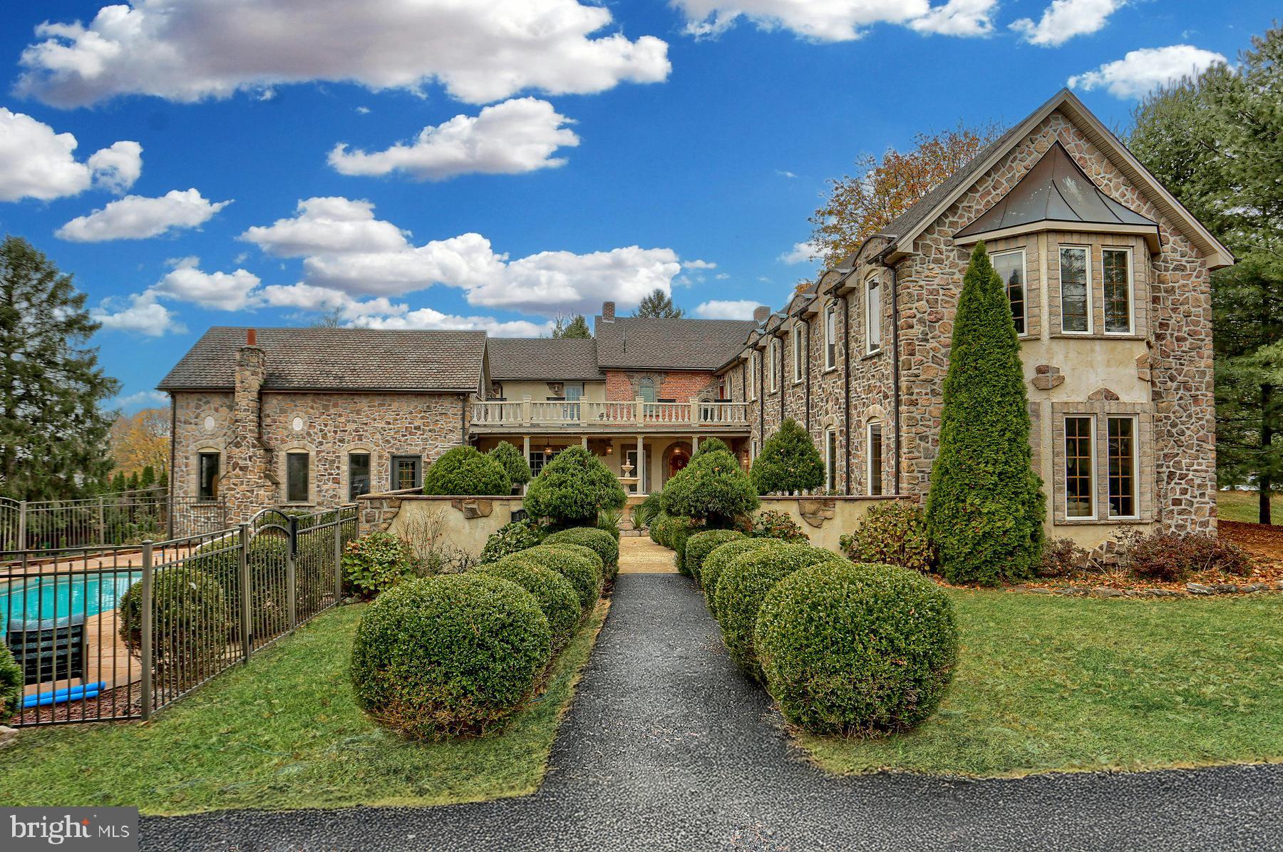 Welcome to a one-of-a-kind retreat that blends modern luxury with historic charm! This spectacular 5,200+ sq ft custom home, including a 1,000 sq ft in-law suite, is designed for those who value unique architecture, exquisite craftsmanship, and space to entertain. From the moment you step through the courtyard entrance with its serene and lush landscaping, you'll feel transported to a world where comfort meets creativity. This historic home has a beautiful stone front and features a brand NEW roof!. Exterior balconies overlook landscaped entrance and courtyard. In total there are 5 bedrooms and 4 1/2 baths!
The main home boasts a striking two-story family room, reimagined from a local barn, with soaring cathedral ceilings, exposed beams, and a loft/office. Cozy up by the fireplace, which anchors this remarkable gathering space. The addition built in 2005 created a separate wing featuring an in-law suite with a kitchenette, a spacious living room with a gas fireplace, a large bathroom, and its own laundry room — ideal for extended family or guests.
This home offers five total bedrooms, including two en-suites, as well as a large, bright eat-in kitchen with stainless steel appliances, bay window seating, and stunning hardwood floors throughout the formal living and dining rooms. There are 3 fireplaces one of which is in the dining area and formal sitting room which could serve as a den/study as well w/ custom built-ins. Upstairs you'll enjoy the private balcony great for summer nights and relaxation. Additional bedrooms upstairs along with the 2nd primary bedroom depending on how the home is used. The options are endless!
Outside, the 15x29 in-ground heated, Gunite pool with a stamped concrete and paver patio creates an entertainer's paradise. With multiple patios and porches to enjoy, you'll have endless options for outdoor living. A walk-out basement with its own private patio awaits your finishing touches and offers even more potential.
With multi-zone heating and cooling, this home combines modern convenience with timeless character, from its stone masonry and white brick exterior to its custom finishes.... Conveniently located this property is truly a must-see for those looking for a home as unique as they are. Come be a part of this historic home in Mechanicsburg!