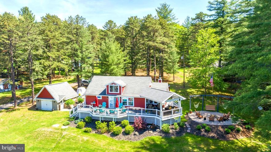 STUNNING LAKEFRONT COTTAGE with private type A dock, beautiful lake views and gorgeous sunsets! This original 1950's 3 bedroom, 2 bath cottage has had just 2 owners and was completely rebuilt and lovingly upgraded with an eye towards maintaining the original lake cottage feel while creating spaces for many friends and family to gather.  Guests can be reading by the wood burning fireplace in the cozy sunroom with amazing lake views while others are watching a game in the family room.  The dining area can fit 10-13 for game nights while the kitchen island is the main attraction for friends enjoying evening cocktails.  The original footprint has expanded square footage to add the dining area with vaulted ceilings, the sunroom as well as the upper level finished area.  The outside Trex deck with heat and television welcomes a respite from the sun or is a beautiful place to take in a Garrett County snowfall.  The firepit, lakeside area and dock are the icing on the cake!  Penn Point neighborhood is one of the original neighborhoods on the lake and is known for the best sunsets and serene atmosphere.  Home conveys furnished with a few seller exclusions.  It also conveys to include many handcrafted tables from Garrett County native Kenny Michaels and many of the home details that have been up-cycled from findings in the original cottage including  vintage skis, oars, and a chandelier crafted from vintage Oakland dairy milk bottles.  Schedule your tour today to see this wonderfully cared for home and appreciate all it has to offer.