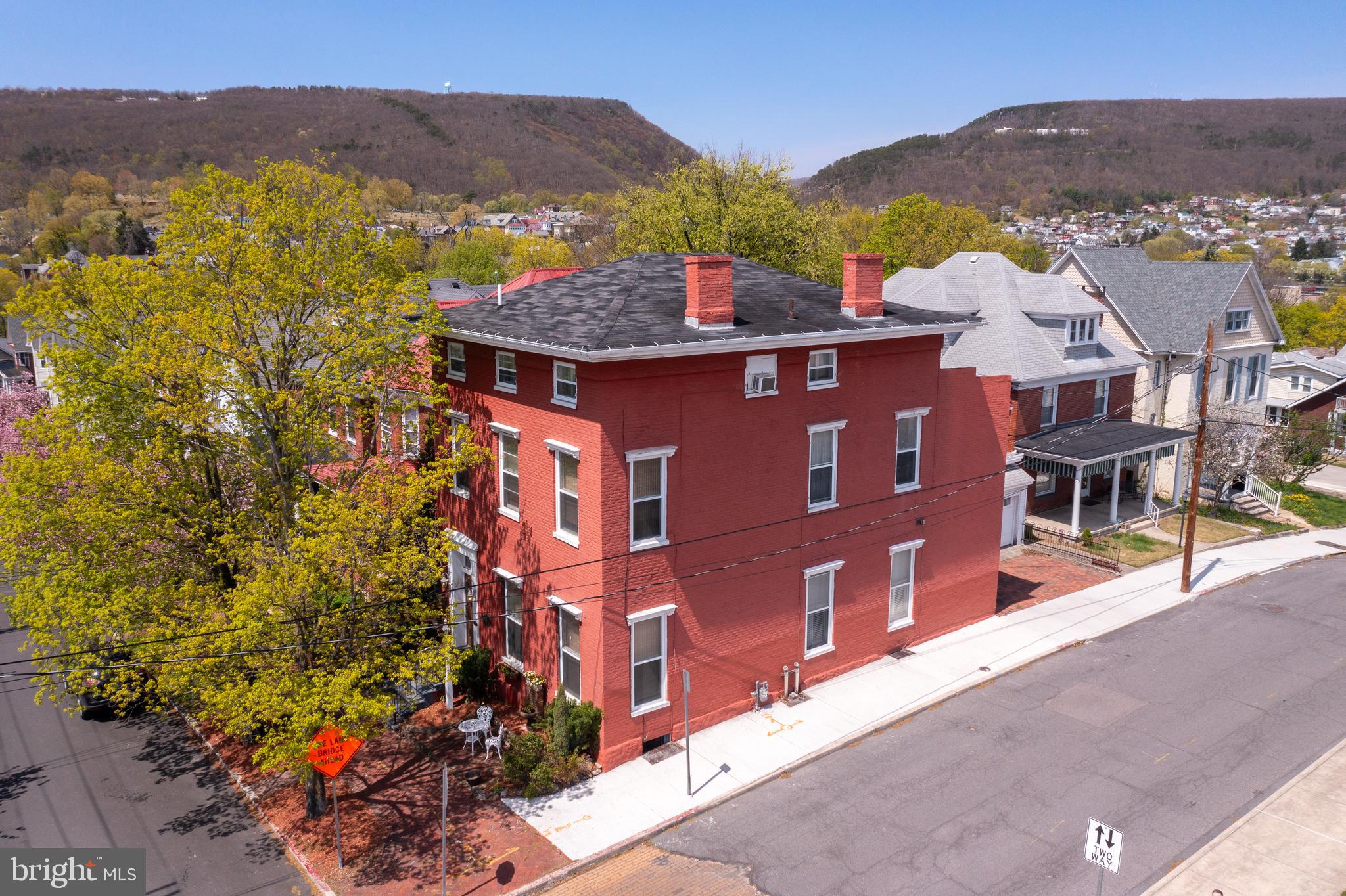 HISTORIC BRUCE HOUSE INN LOCATED MINUTES AWAY FROM DOWNTOWN CUMBERLAND AND ALLEGHENY PASSAGE/C&O CANAL! Welcome to 201 Fayette Street. This historic, federal style home was built in 1840 and is nestled in the mountains of Cumberland. It has been lovingly restored and features 5 guest suites with 5 attached bathrooms AND a 1 bedroom, 1 bathroom apartment. Currently an established Airbnb, this property is zoned Residential-Office and could be a single-family home, a bed and breakfast, a boarding house/group home, a professional office (with living quarters above it) or short-term rentals. It is equipped with sprinklers, emergency lighting, has been re-wired, plumbing updates, central air, newer furnace and newer tankless hot water tank. The main level features a beautiful entry, a common room with a kitchenette and a gas fireplace and two charming guest suites with attached full bathrooms. The back suite, lovingly known as the "Library" has a spacious sitting room and beautiful woodwork throughout. The second floor features a private apartment with a full kitchen, living room, bedroom, full bathroom and large deck overlooking the City of Cumberland as well as a third guest suite with an attached full bathroom with a claw-foot tub. The third floor offers two more guest suites (both with attached full bathrooms). There is also a full basement with laundry and room for storage as well as an attached two-car garage for parking and extra storage. Walking distance to both the Allegheny Passage, C&O Canal and the recently redeveloped Baltimore Street with multiple local shops and restaurants. This property is extremely unique and must be seen in person to full appreciate! Reach out for a link to the 3D tour!